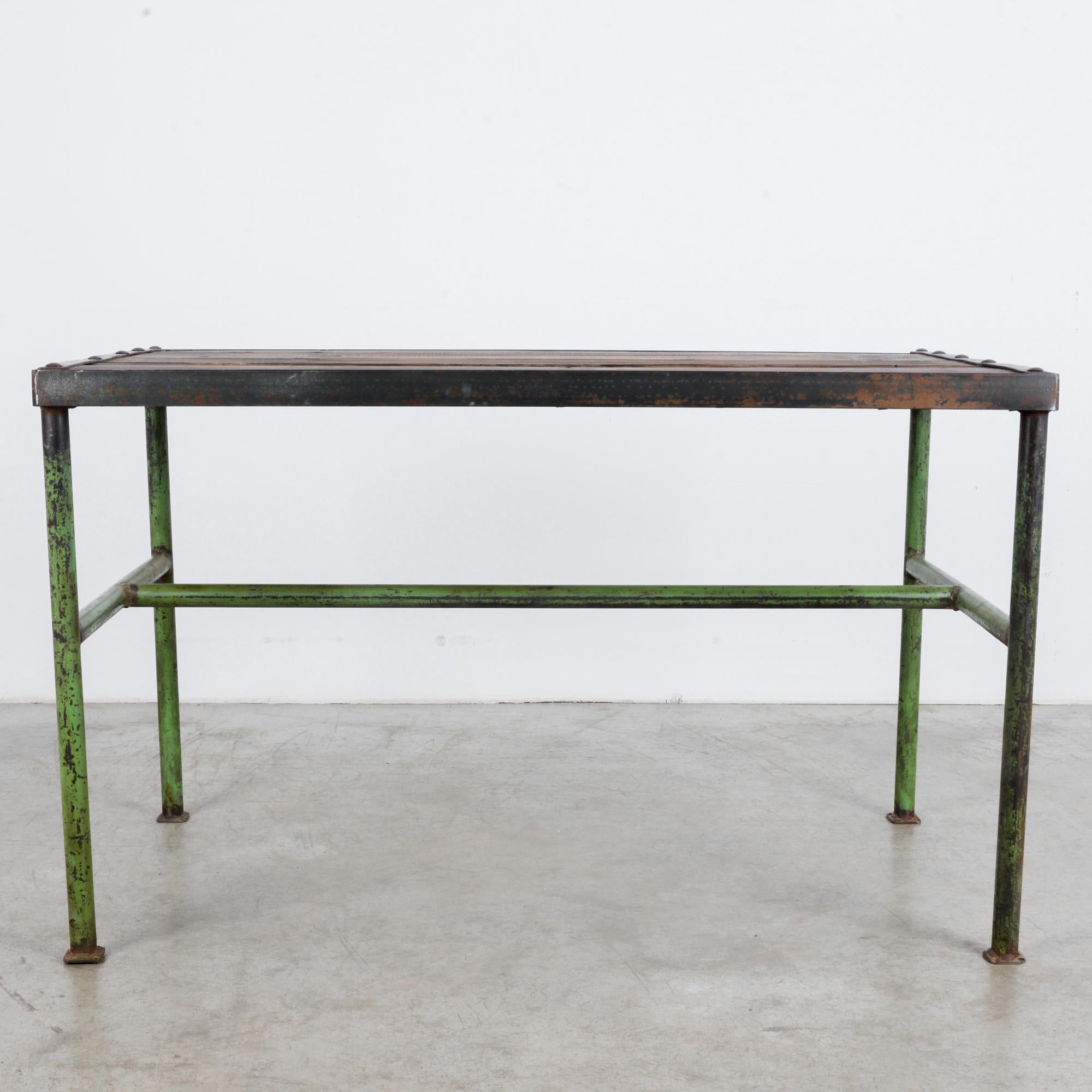 A Czech made metal work table with wooden top, produced, circa 1960. The dark tone of the wood works well with the iron casings holding the piece together. This versatile piece comes directly out of a midcentury workshop. It calls to mind creation,