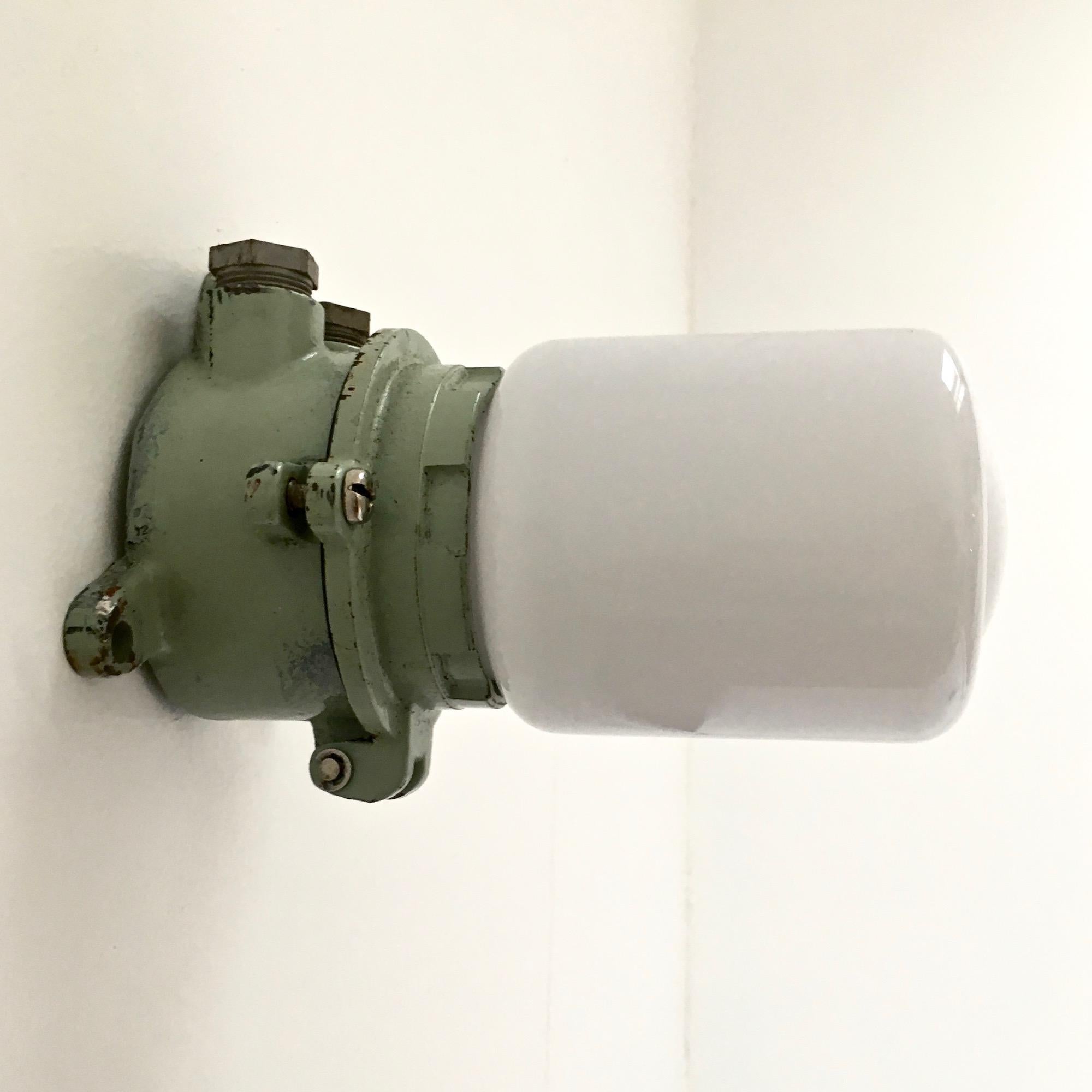 Wall light in white opaline glass and green painted cast iron holder. Industrial style; strong and fragile.