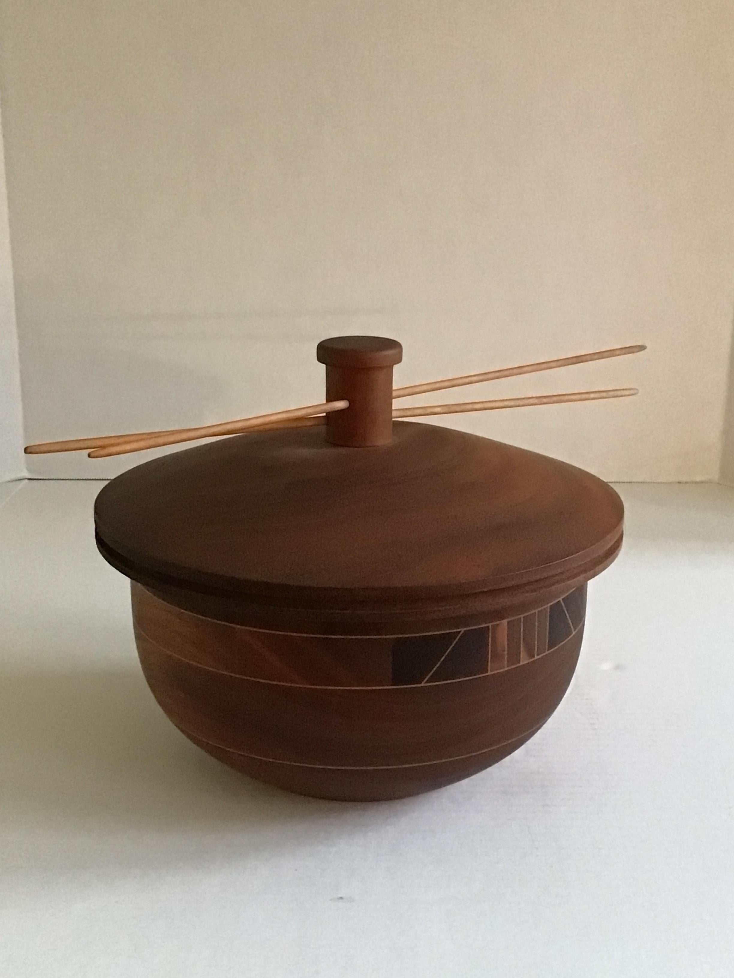 This 1960s Laminated Wood Bowl/Box with Lid features a geometric pattern throughout both sides of the bowl. Wood top incorporates a pair of sticks through the lid handle (fixed, not moveable)
This would be a welcome natural addition to any modern