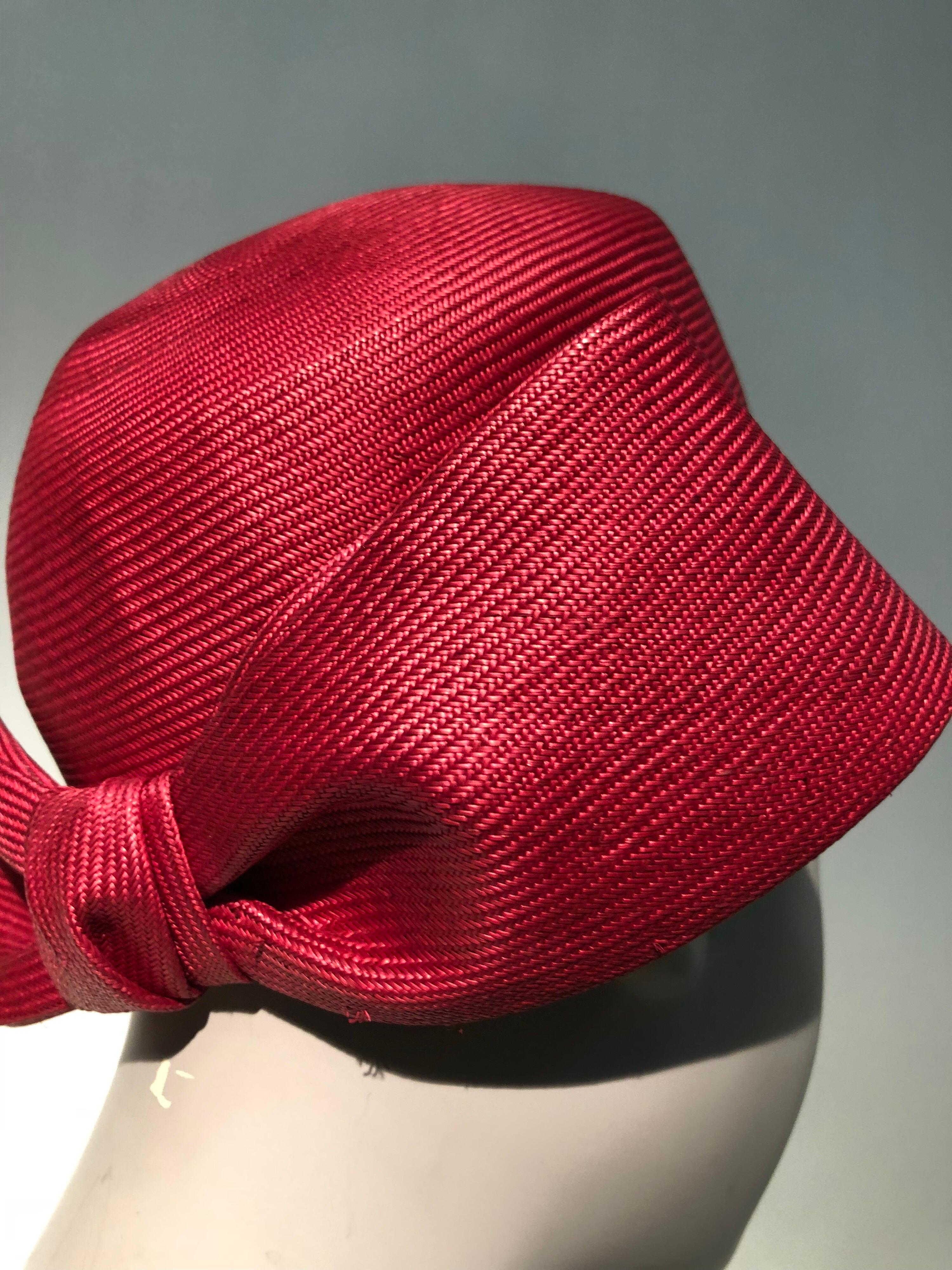 As gorgeous Irene of New York tightly woven fuchsia straw pillbox that is adorned at the back with a large stiffly-structured  straw bow. More than mod!