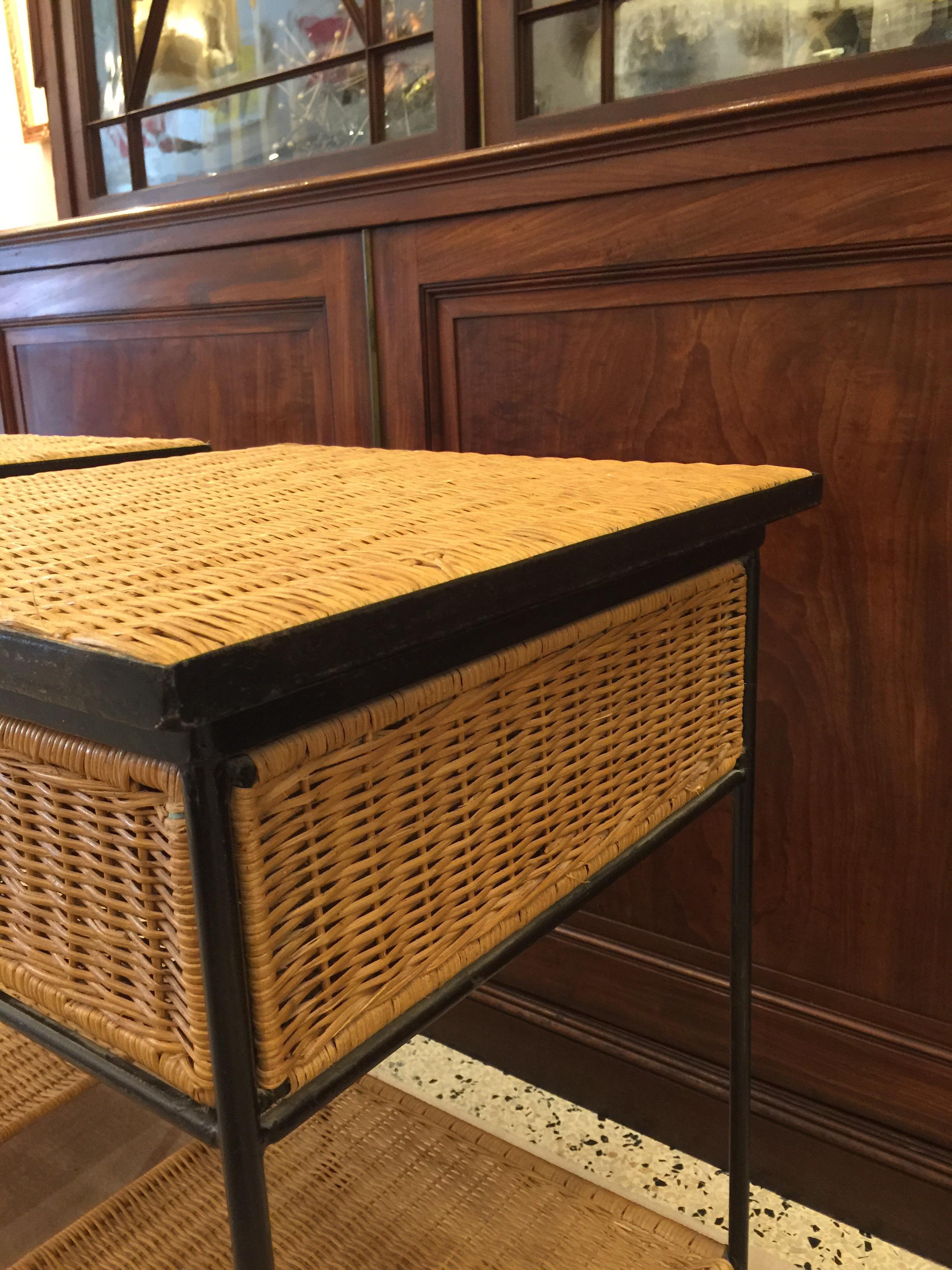 Vintage side tables in black metal frame and wicker. Very well constructed with single full wicker drawer per table and lower shelf. Very similar to work of Paul McCobb and Arthur Umanoff.