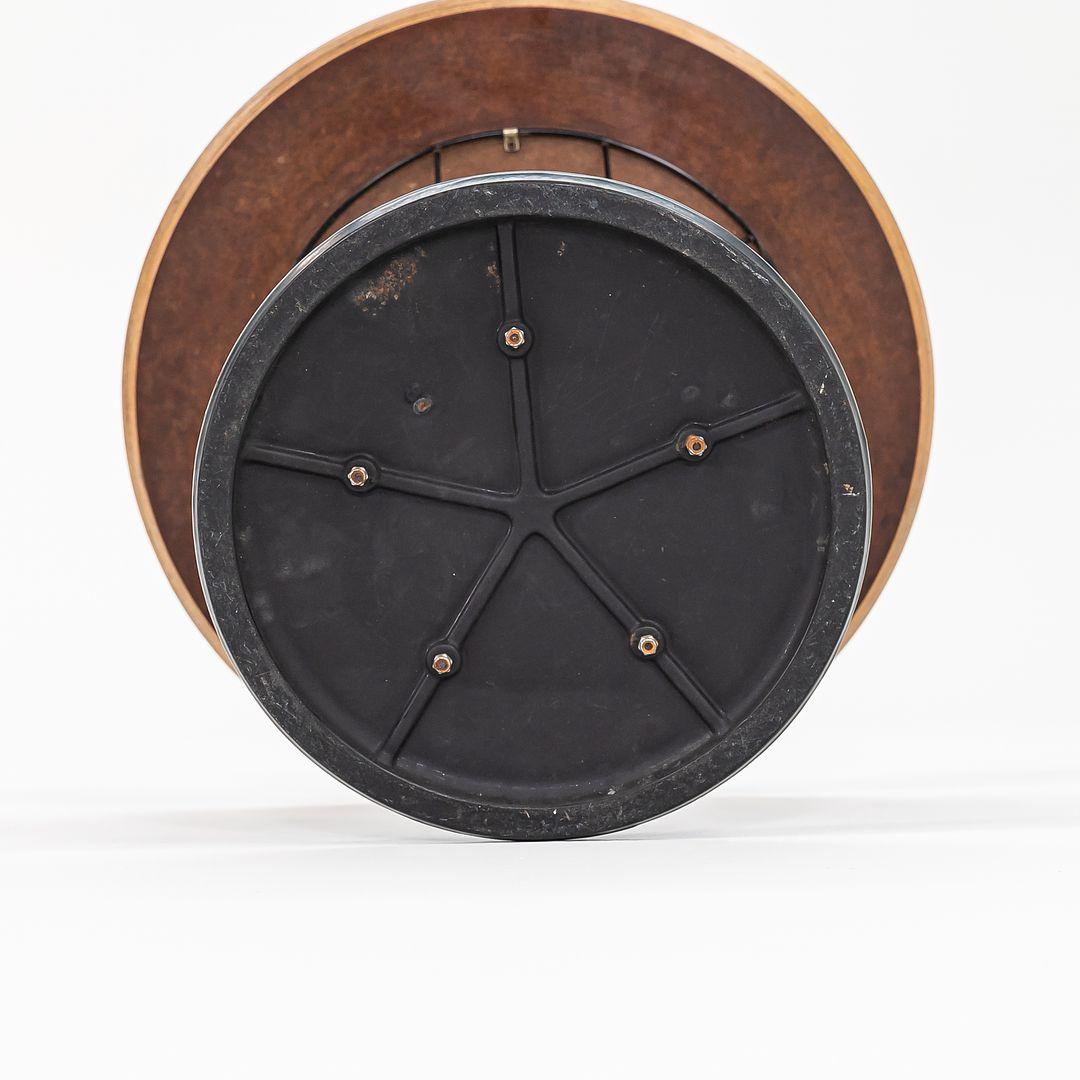 This is a Cyclone side table, model 87, designed by Isamu Noguchi for Knoll in 1953. This example dates to the 1960s. The piece has a cast-iron base which is coated in black porcelain enamel and has a white laminate top. The design‚Äôs chromed-steel