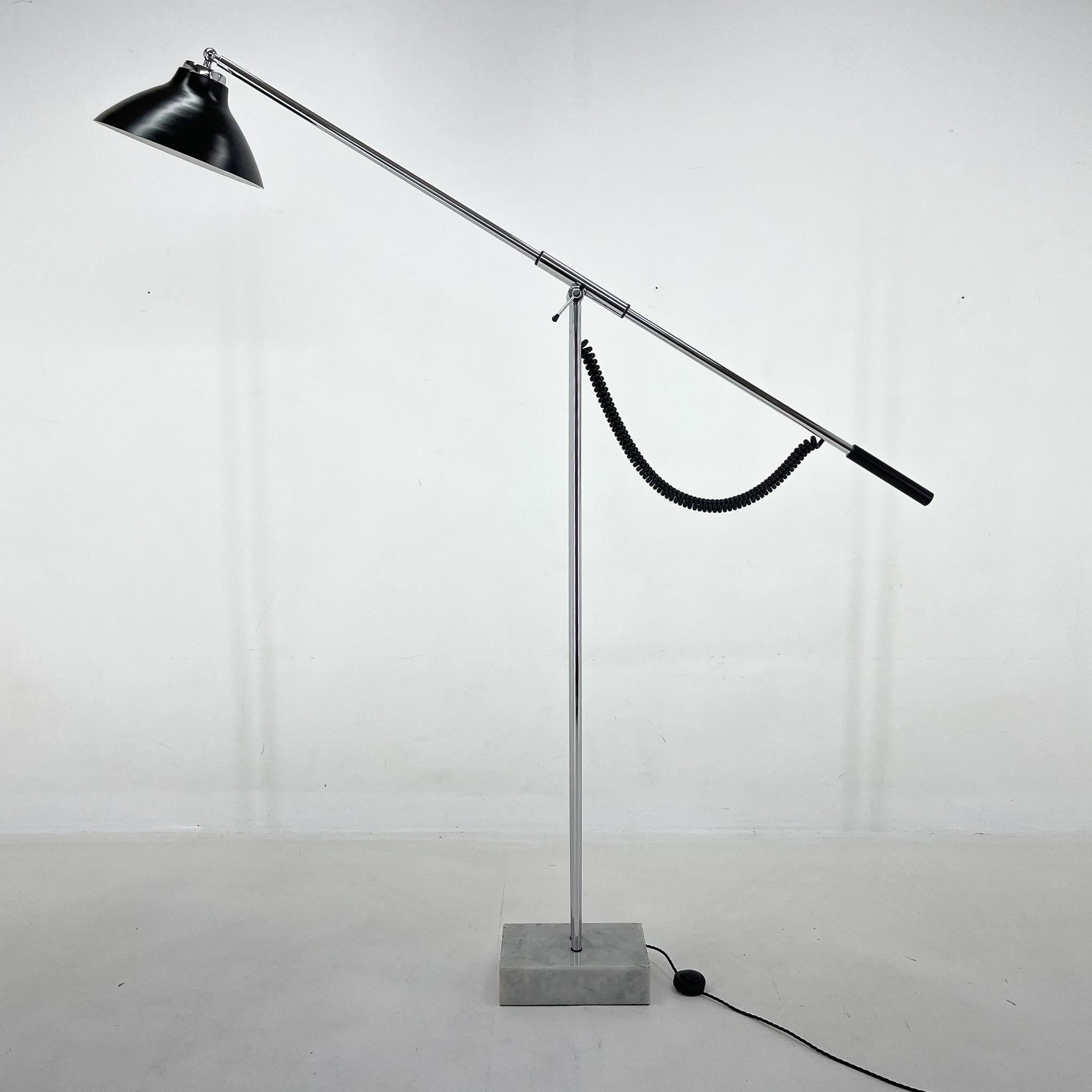 Unique adjustable floor lamp with extendable arm made in Italy in the 1960's. The lamp has a marble base, chrome body, black lacquered shade and has been completely restored and rewired with step-on switch. There are some signs of use on the marble