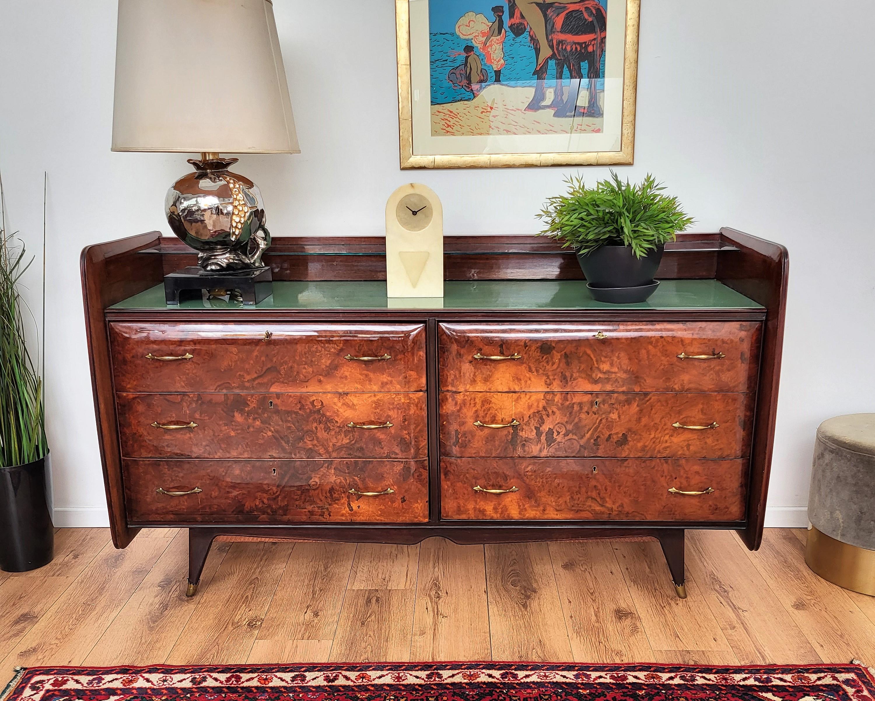 Beautiful Italian 1960s commode, sideboard, credenza, buffet or chest of drawers in elegant and classic wood in its natural graining with gilt brass details such as the drawers handles, the legs feet and side shell decorations. This sideboard has 6
