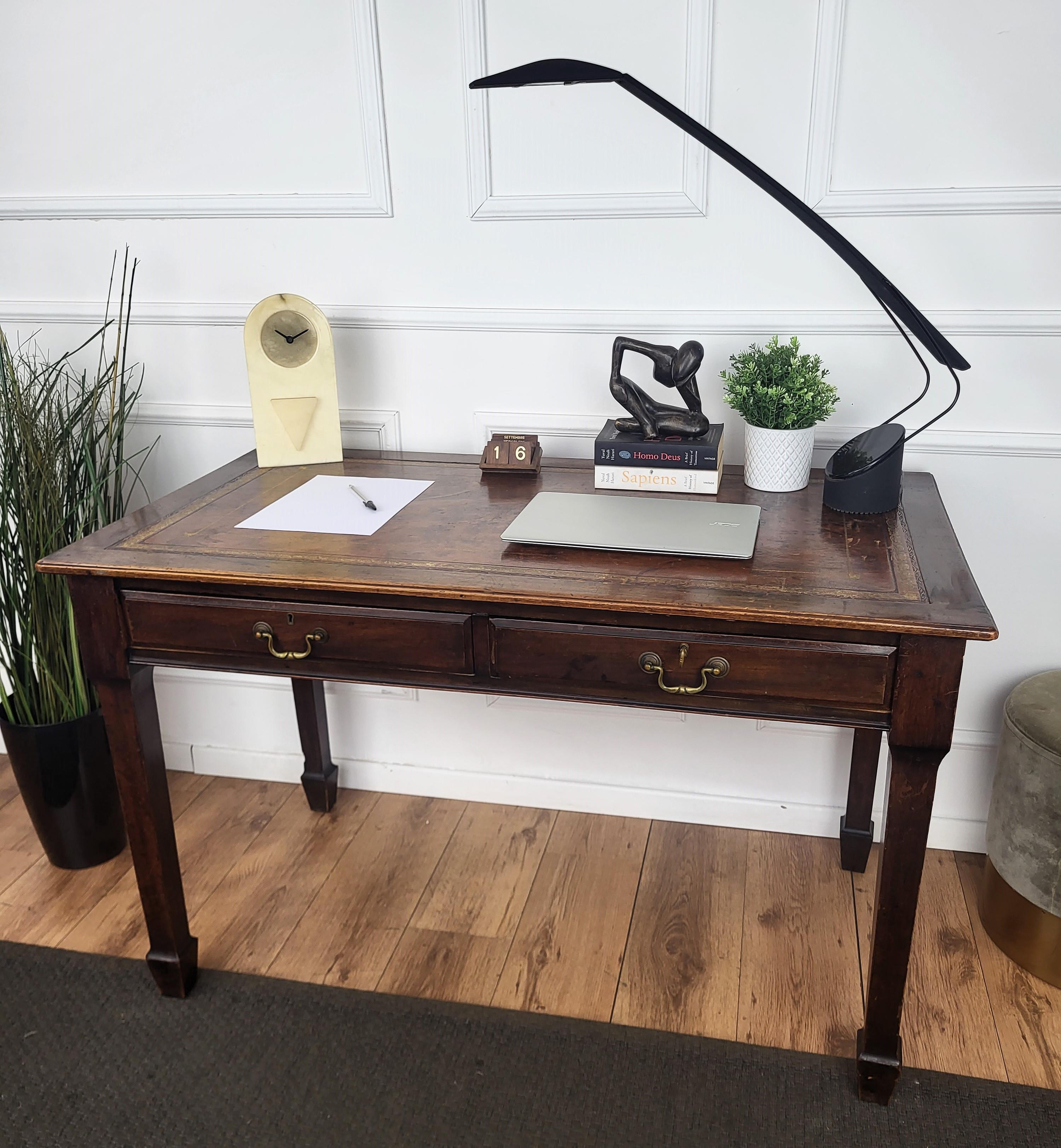 Very elegant Italian Mid-Century Modern desk writing table with stylish carved legs veneer wood with two central drawers. This beautiful piece is completed by the top that is inset with a gilt tooled leather writing surface, molded edges and the