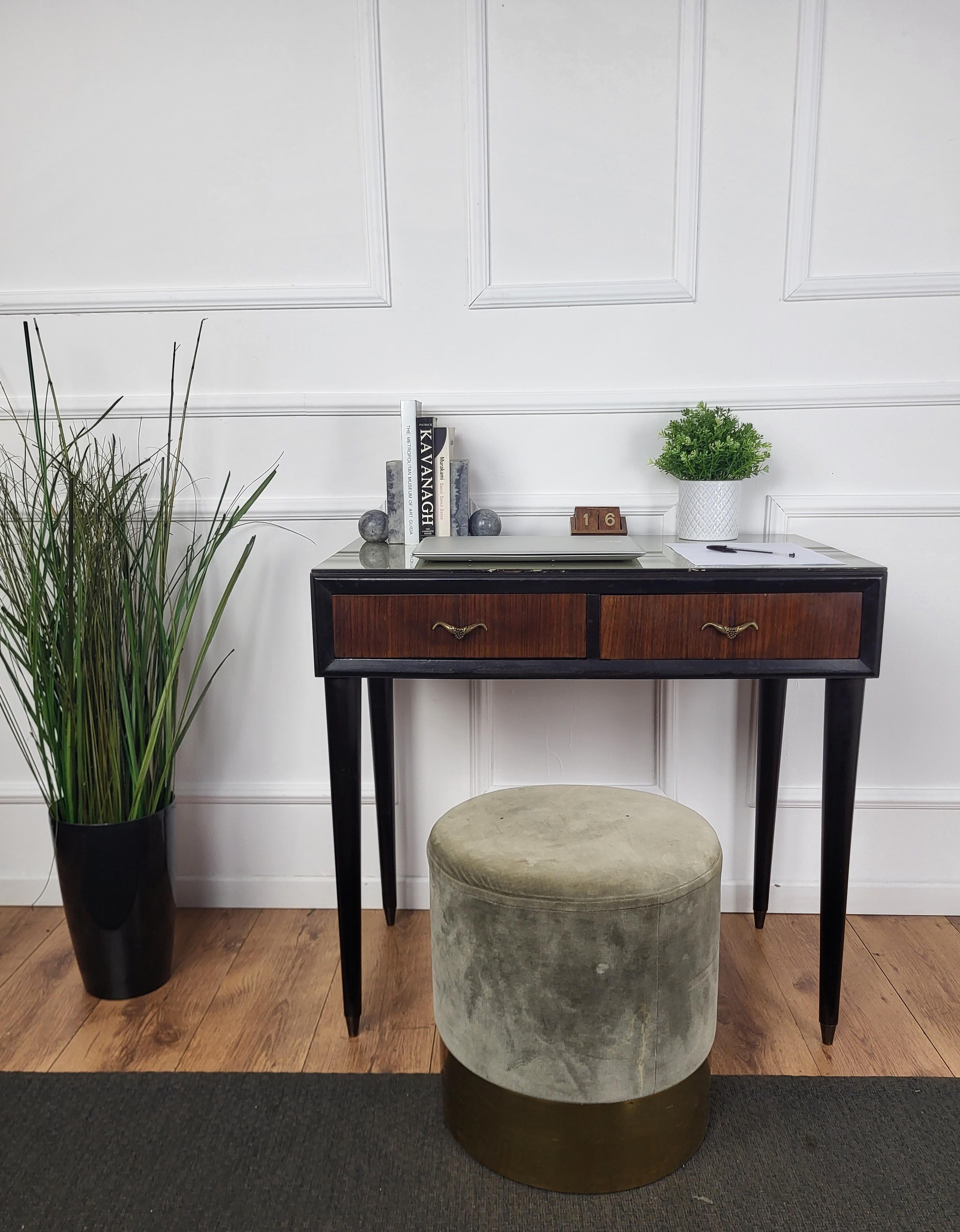 Very elegant Italian Mid-Century Modern small desk or writing table with stylish legs and veneer wood with two drawers. This beautiful piece is completed by the glass top and the brass drawers handles. Ideal in any room as a small stand alone corner