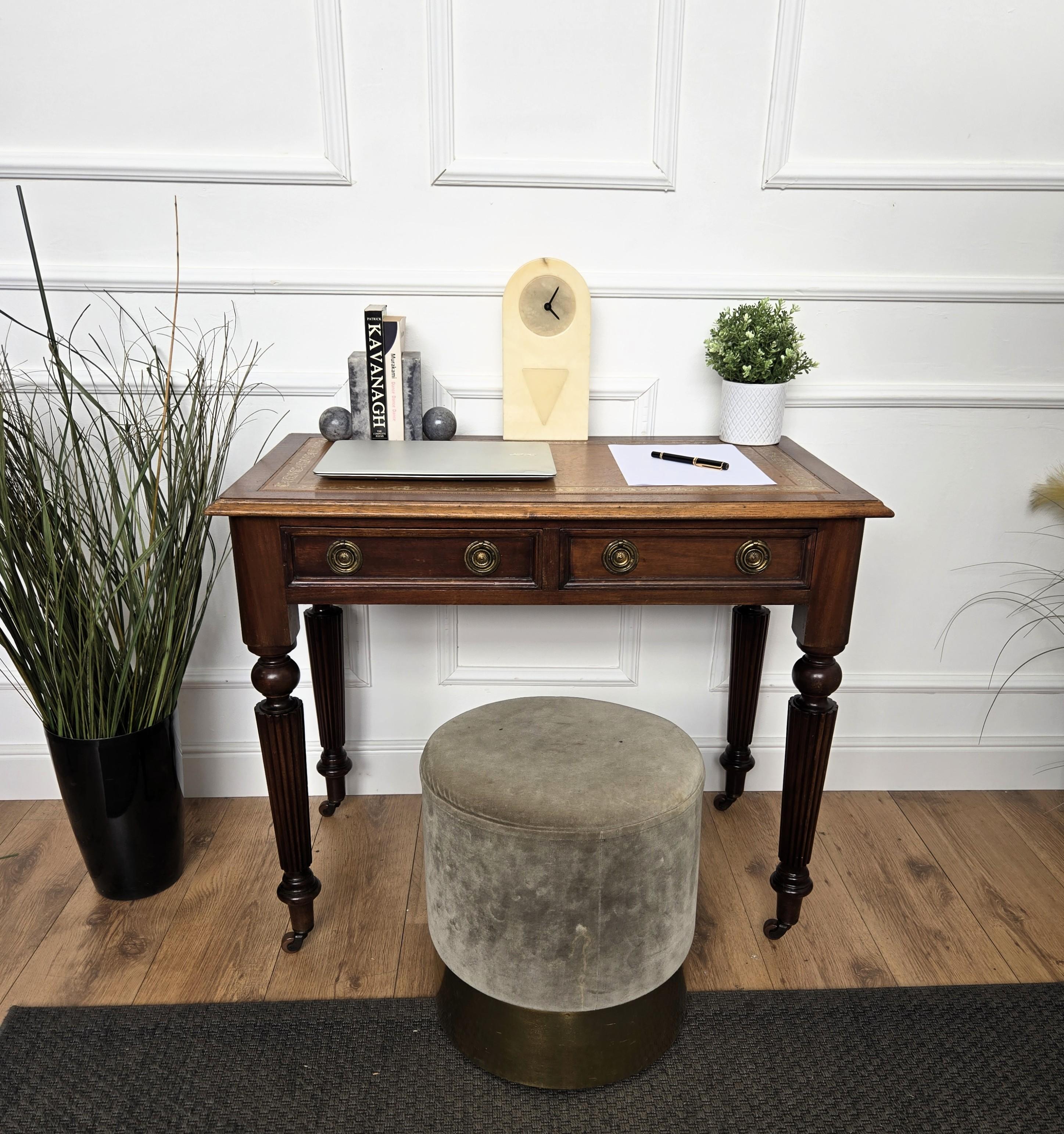 A gorgeous and absolutely classic regency style executive writing desk or bureau plat desk in carved wood, with embossed leather top, original brass handles in the two drawers and baluster-shaped and grooved/channelled legs ending with feet casters