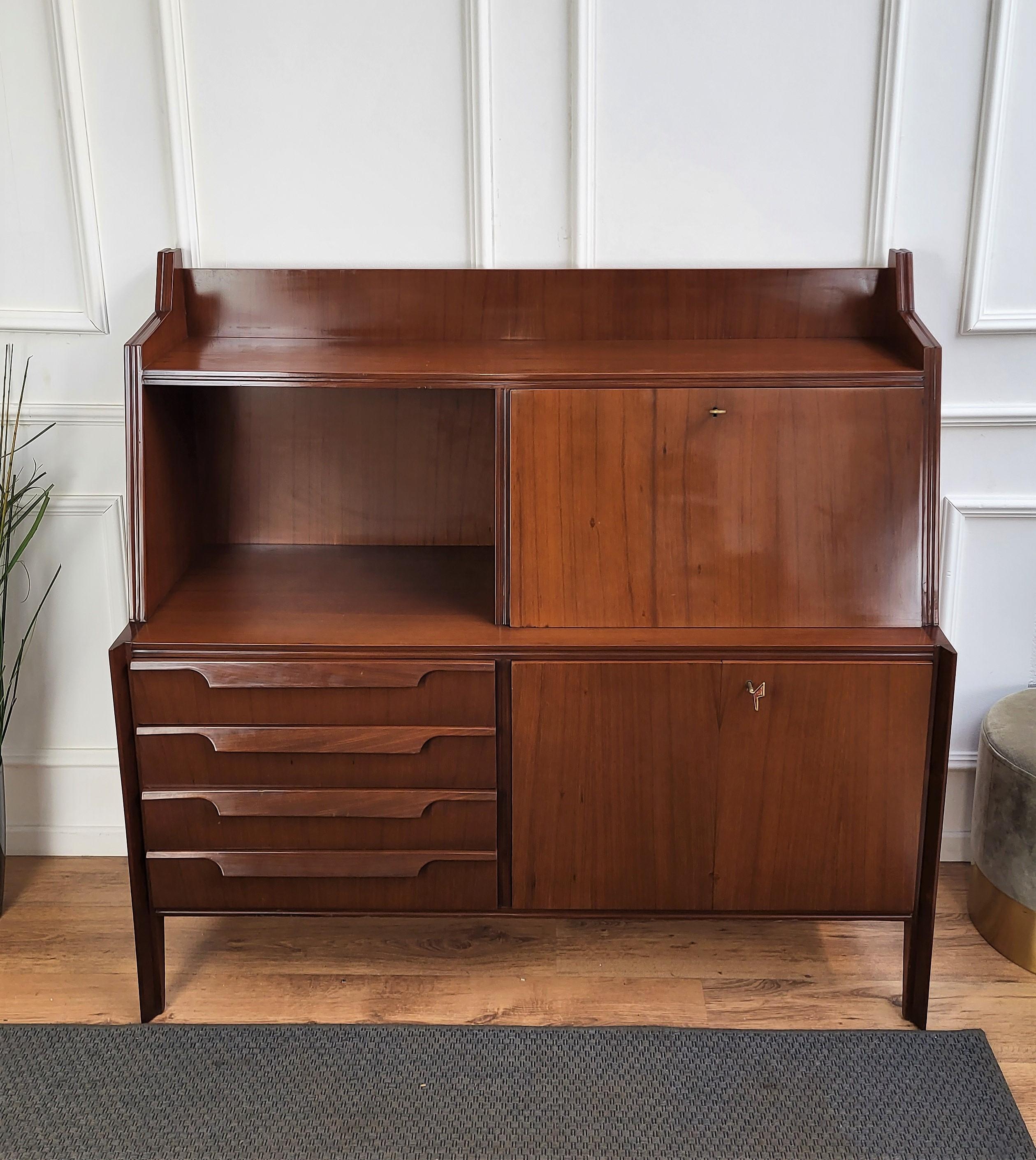 Important and elegantly shaped Italian Art Deco Mid-Century Modern sideboard or credenza. With its greatly designed edges, frames and details in beautiful wood, the credenza has an upper shelf, a drop-flip central opening and in the down part two