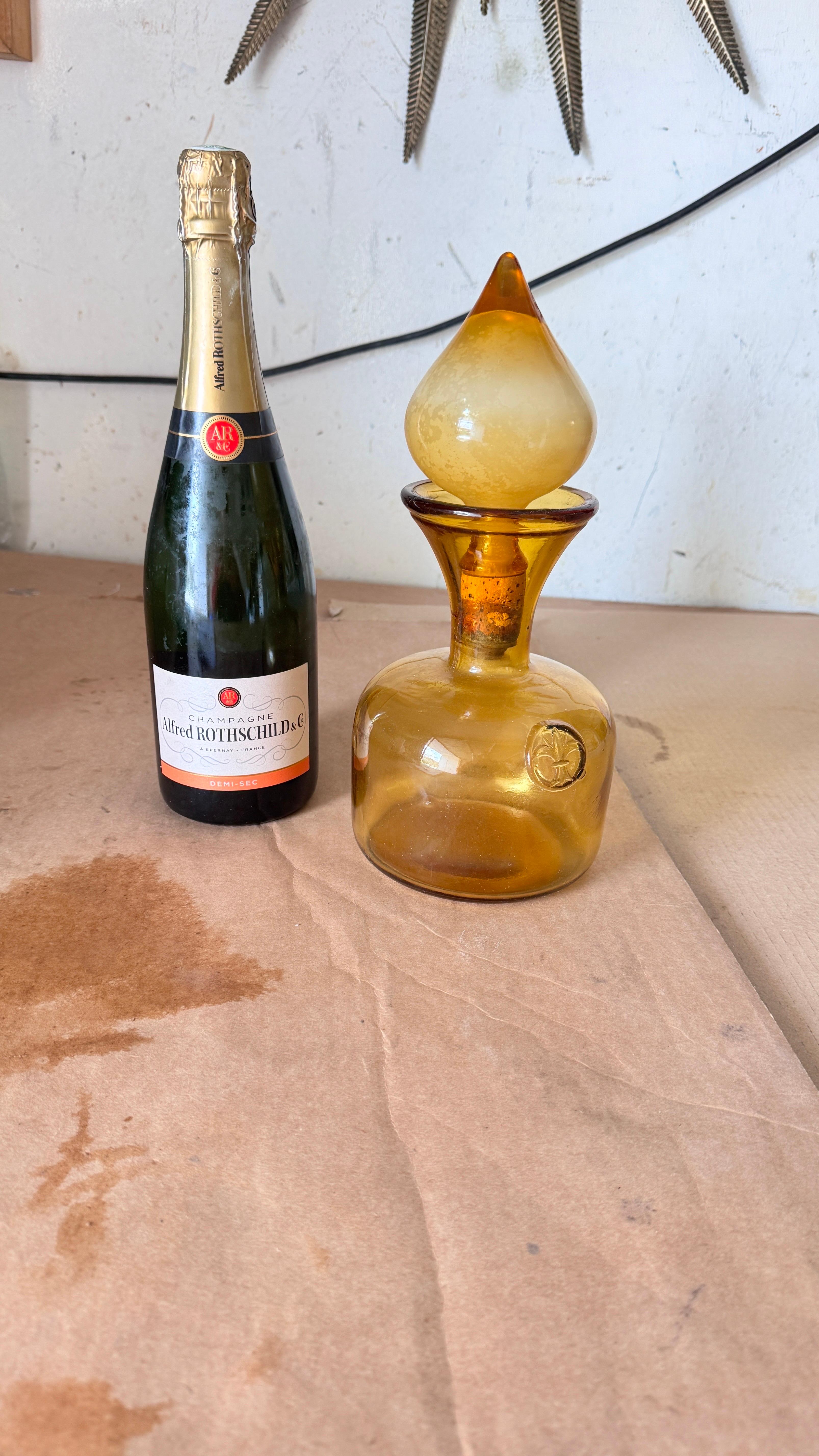 1960s Italian Art Glass Bottle with Large Blown Glass Stopper, Yellow-Orange Hue

Description:
This stunning 1960s Italian art glass bottle is a striking decorative piece, featuring a bold yellow-orange color and an impressive blown glass stopper.