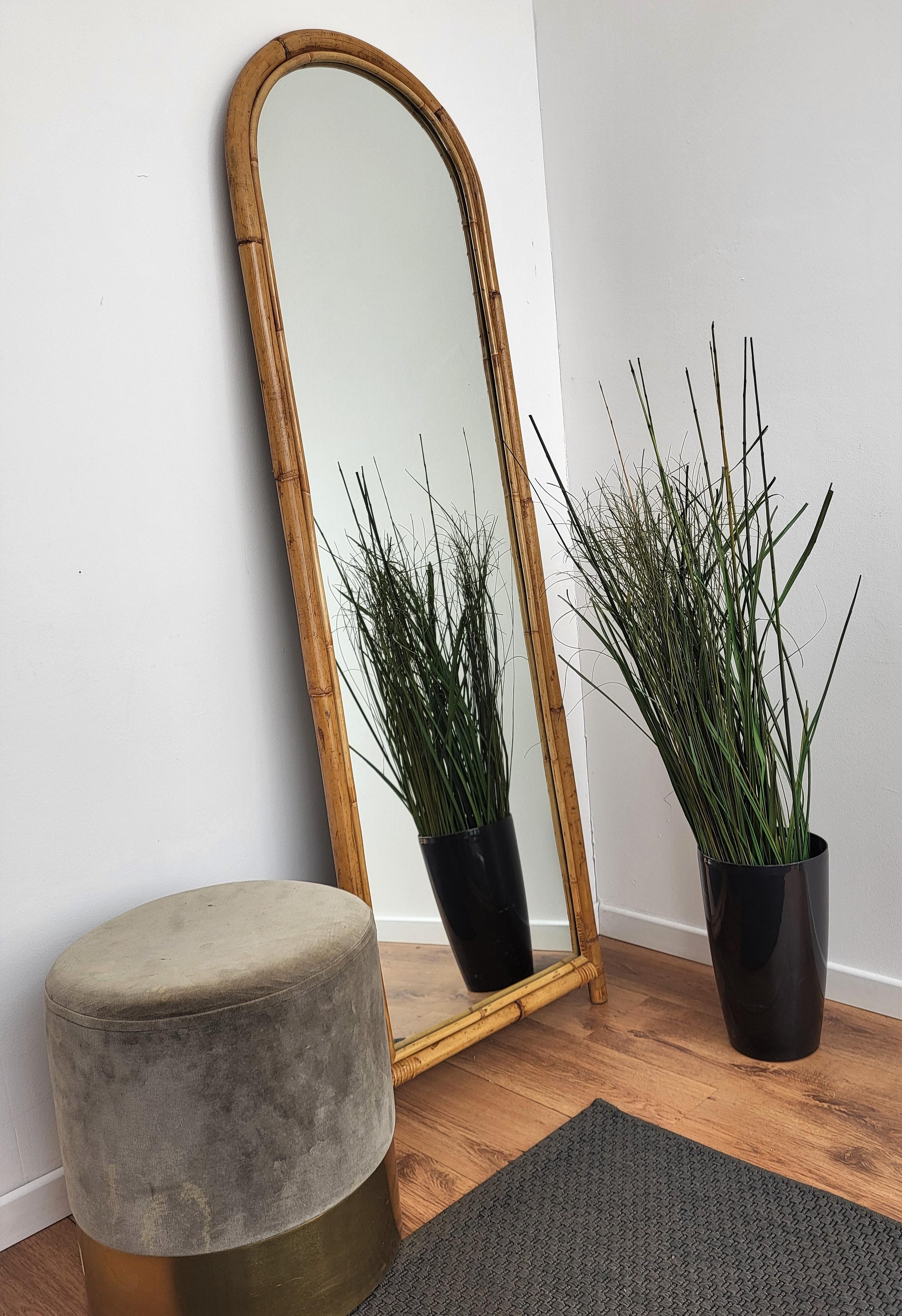 Beautiful 1960s Italian Mid-Century Modern arched long mirror, perfect in any room or in a bedroom. The mirror can be eithr wall mounted or just stand on the floor thanks to its feet final. This charming piece is in the typical style of Audoux and