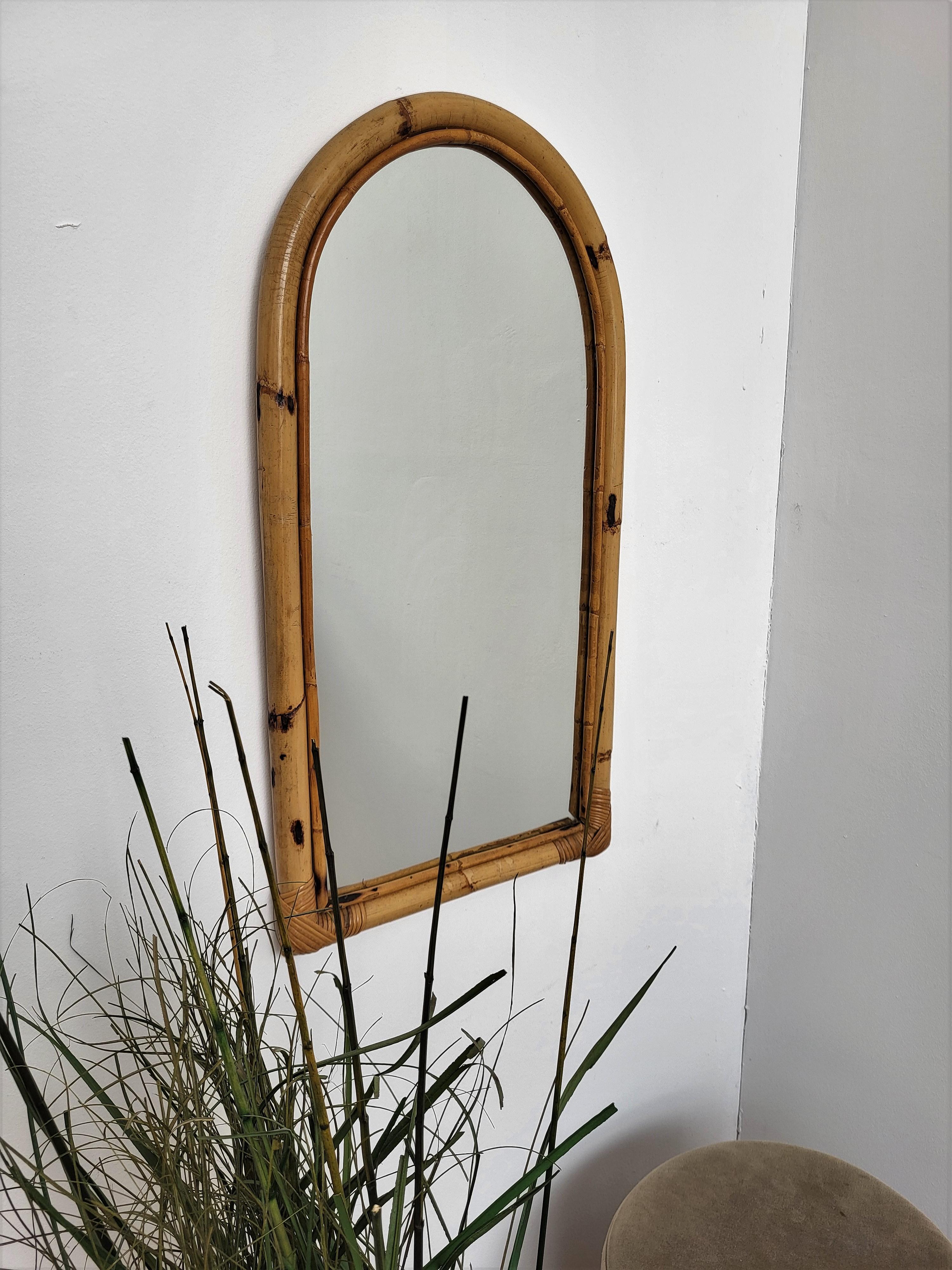 Beautiful 1960s Italian Mid-Century Modern arched mirror, perfect in any room or in a bedroom. This charming piece is in the typical style of Audoux and Minet where the organic beauty of the woven materials is timeless and Classic, making bamboo and