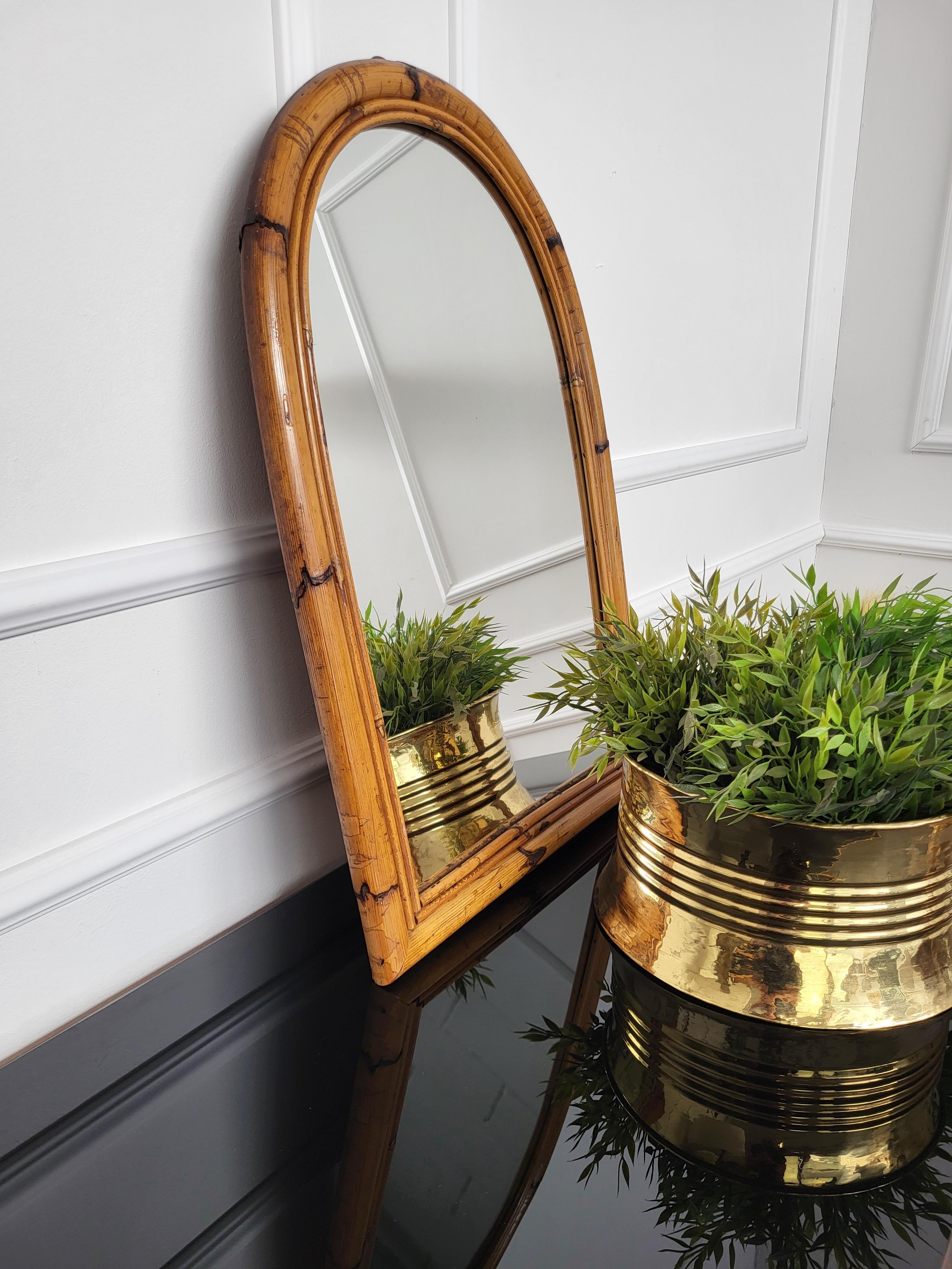 Beautiful 1960s Italian Mid-Century Modern arched mirror, perfect in any room or in a bedroom. This charming piece is in the typical style of Audoux and Minet where the organic beauty of the woven materials is timeless and Classic, making bamboo and