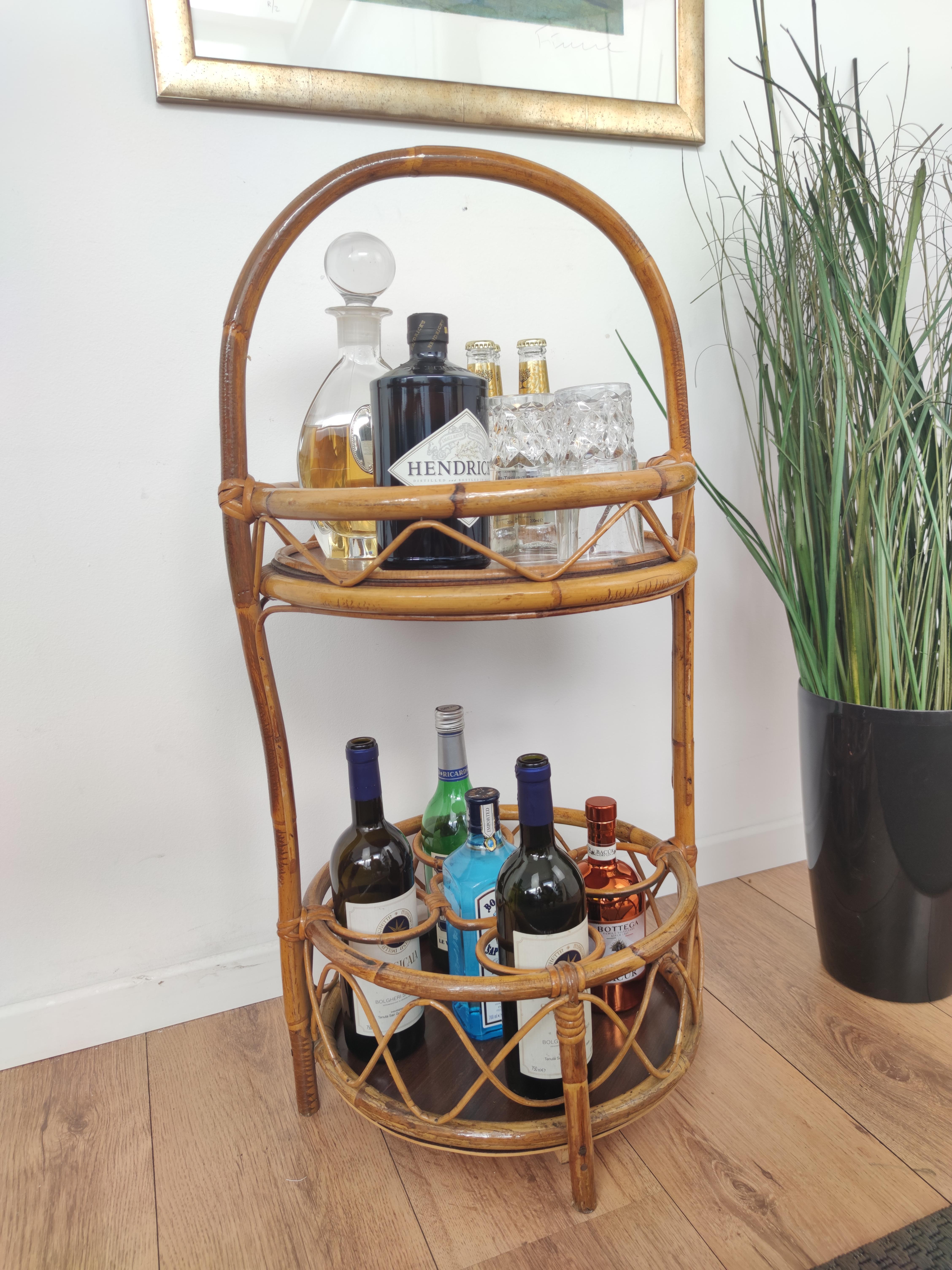 Beautiful 1960s Italian Mid-Century Modern bar trolley featuring two shelves, with the bottom one with three bottle holders. Made of rattan and bamboo. This charming piece is in the typical style of Franco Albini where the organic beauty of the