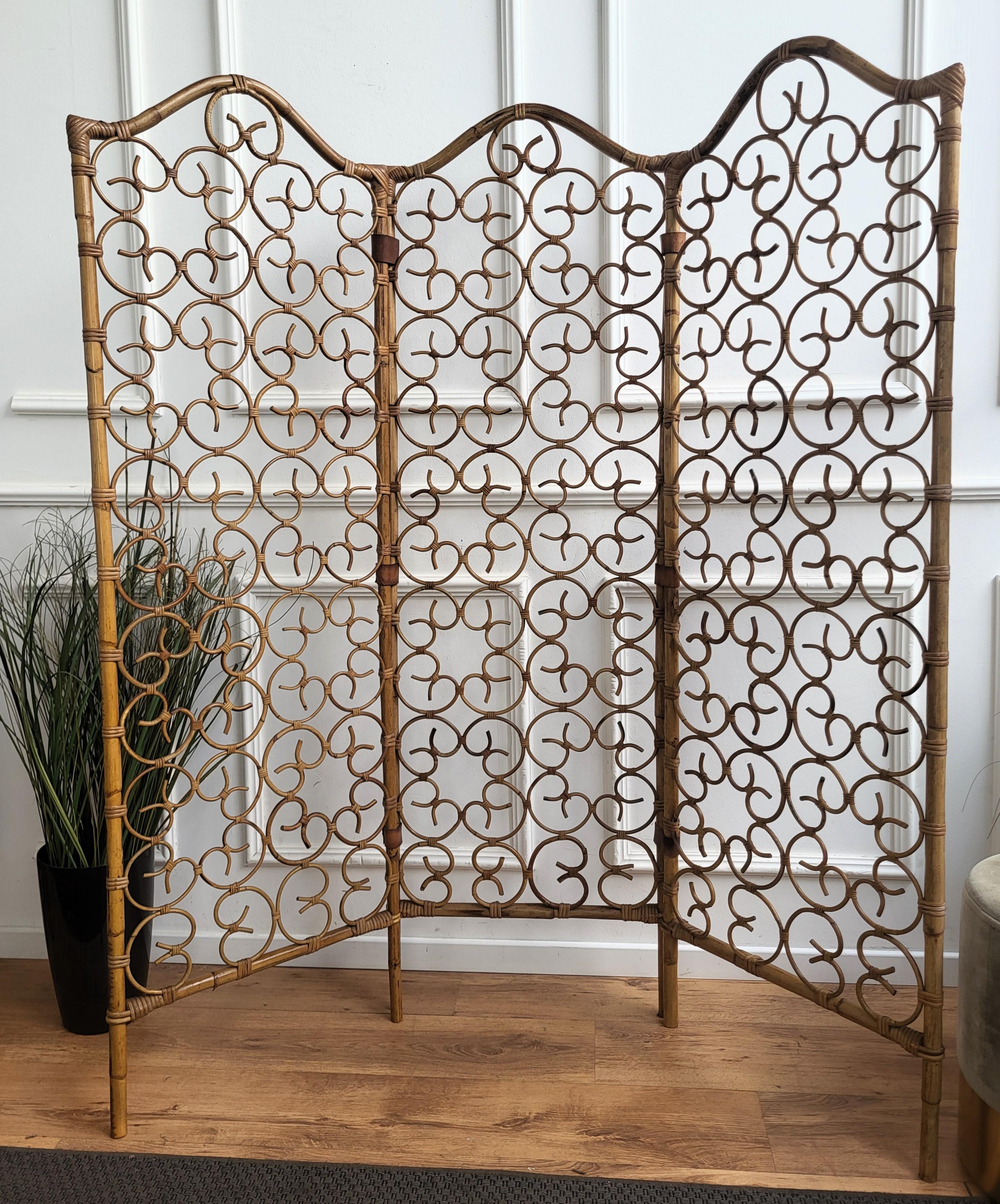 Beautiful vintage Italian bamboo divider screen from the 1970s. Handmade with meticulous artistry, this bamboo cane room divider features a captivating hearts motif repeated pattern design. Connected with brown leather hinges, this vintage piece
