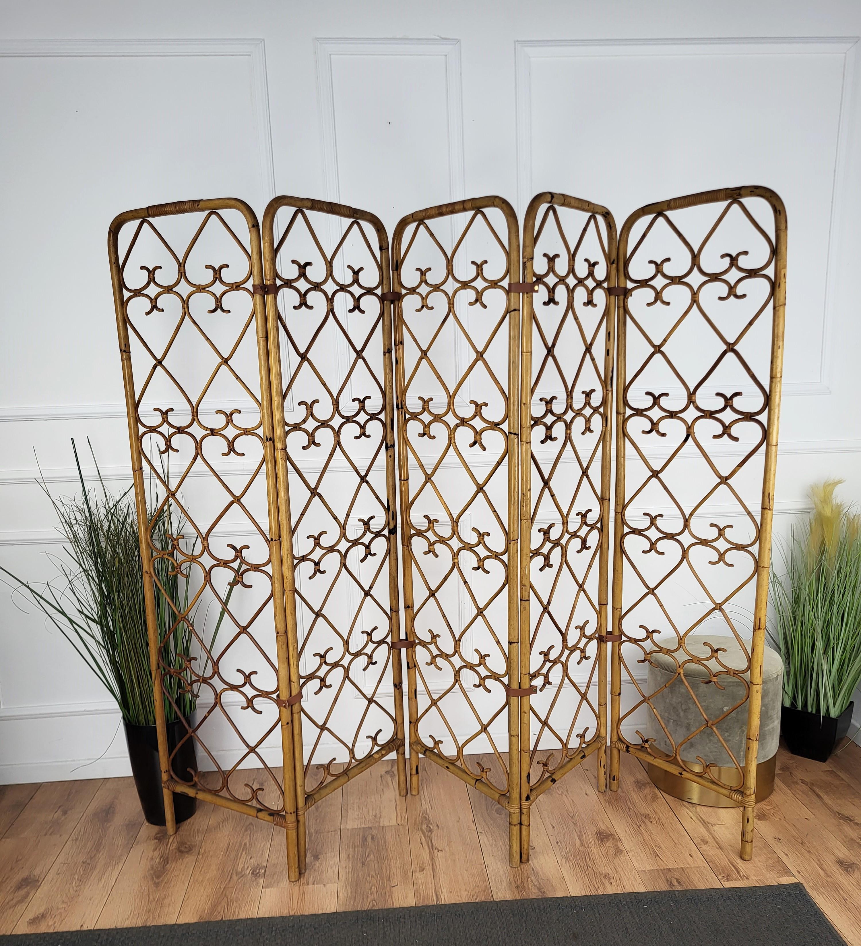 Beautiful vintage Italian bamboo divider screen from the 1970s. Handmade with meticulous artistry, this bamboo cane room divider features a captivating hearts motif repeated pattern design. Connected with new brown leather hinges, this vintage piece
