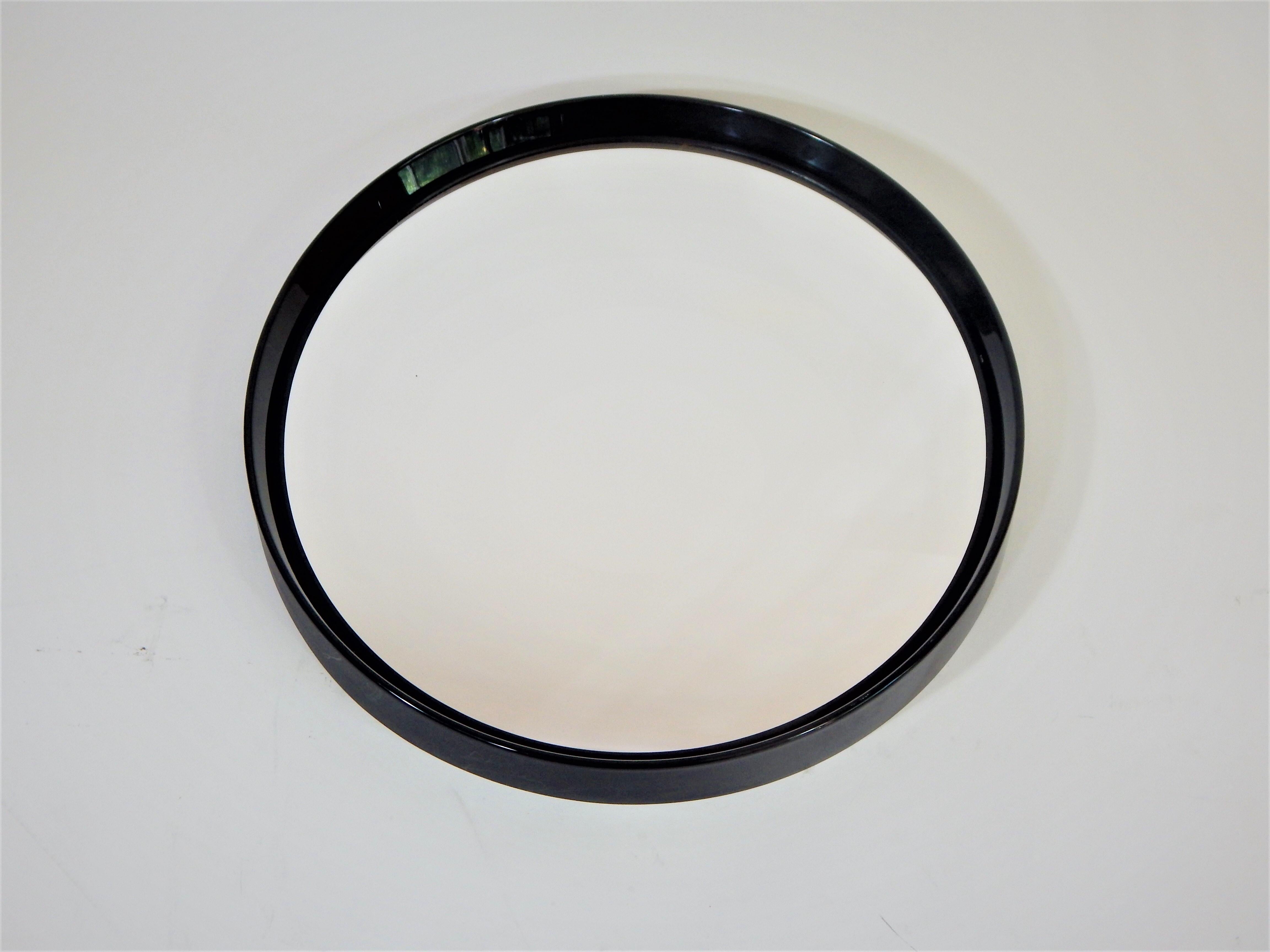 1960s black midcentury round mirror. Designed by Collezione Salc and made in Cantu, Italy. Black glossy finished plastic frame.
Measures: 20 inch diameter, depth when hanging is 2.25.