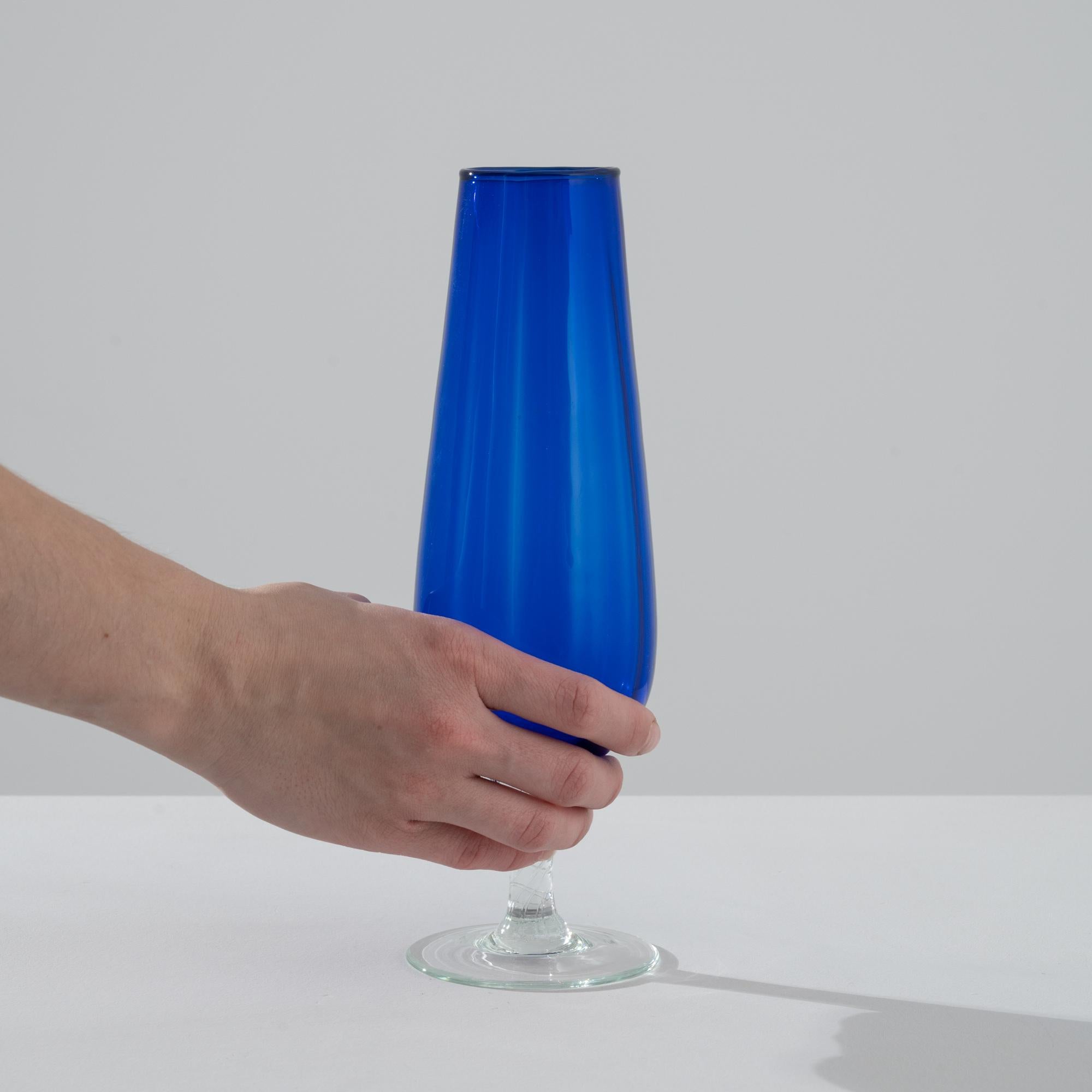 Step into a world of timeless elegance with this magnificent 1960s Italian Blue Glass Goblet, a perfect fusion of bold color and intricate craftsmanship. The deep cobalt blue body of the goblet stands with regal poise, offering a generous bowl that