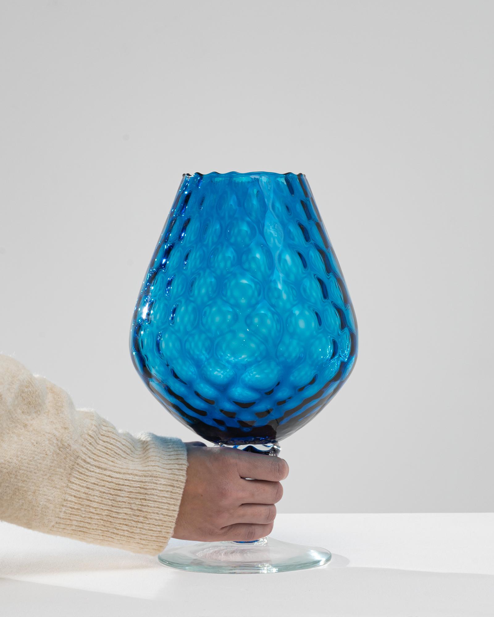 Introducing an exceptional piece from the 1960s, this Italian Blue Glass Goblet is a marvel of vintage design and glassblowing artistry. The vibrant azure blue, reminiscent of the Mediterranean Sea, is complemented by a unique textured surface that