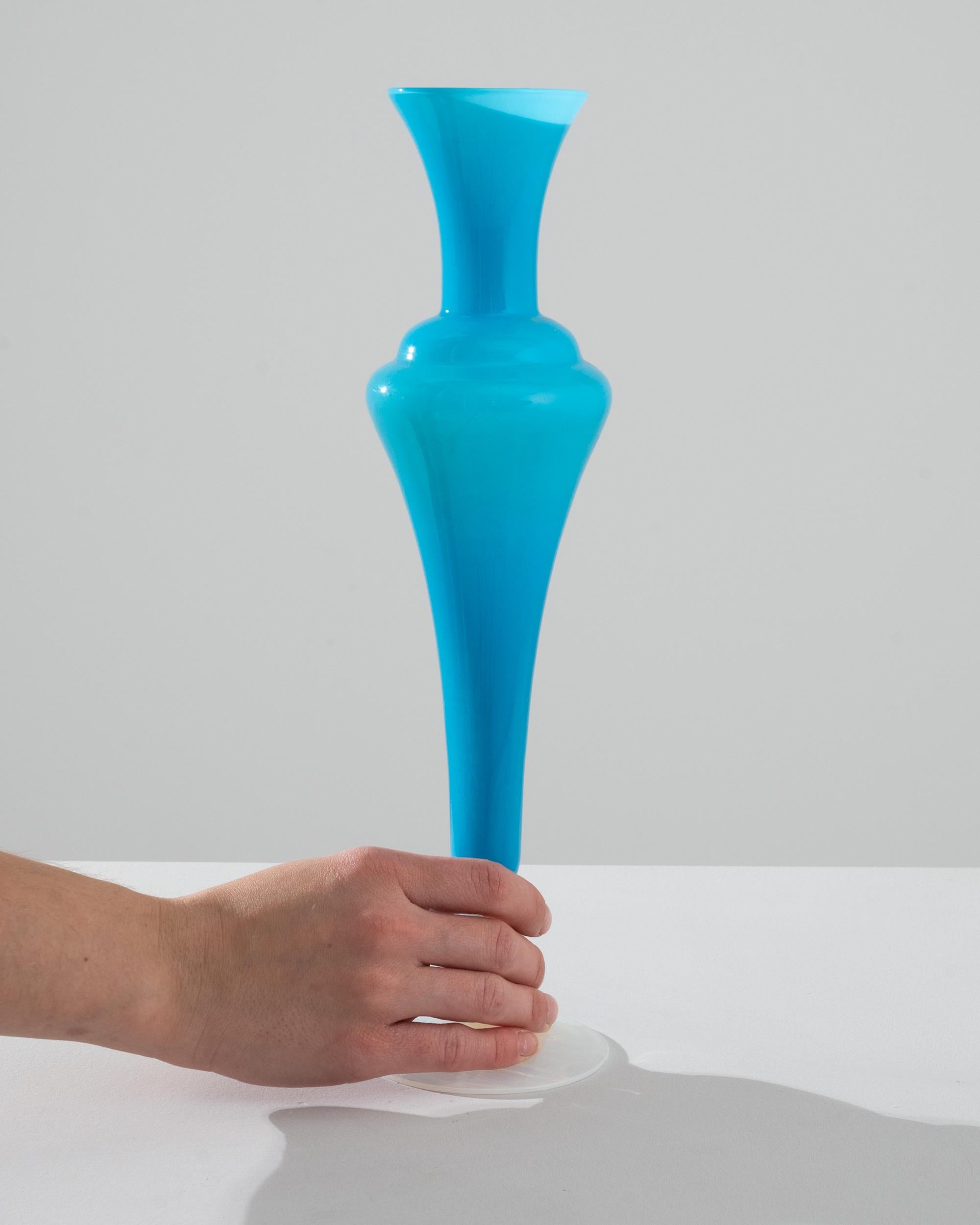 Introducing our exquisite 1960s Italian Blue Glass Vase, a timeless treasure that exudes vintage charm and elegance. Expertly crafted in the heart of Italy, this vase showcases a striking turquoise hue reminiscent of the Mediterranean Sea, which