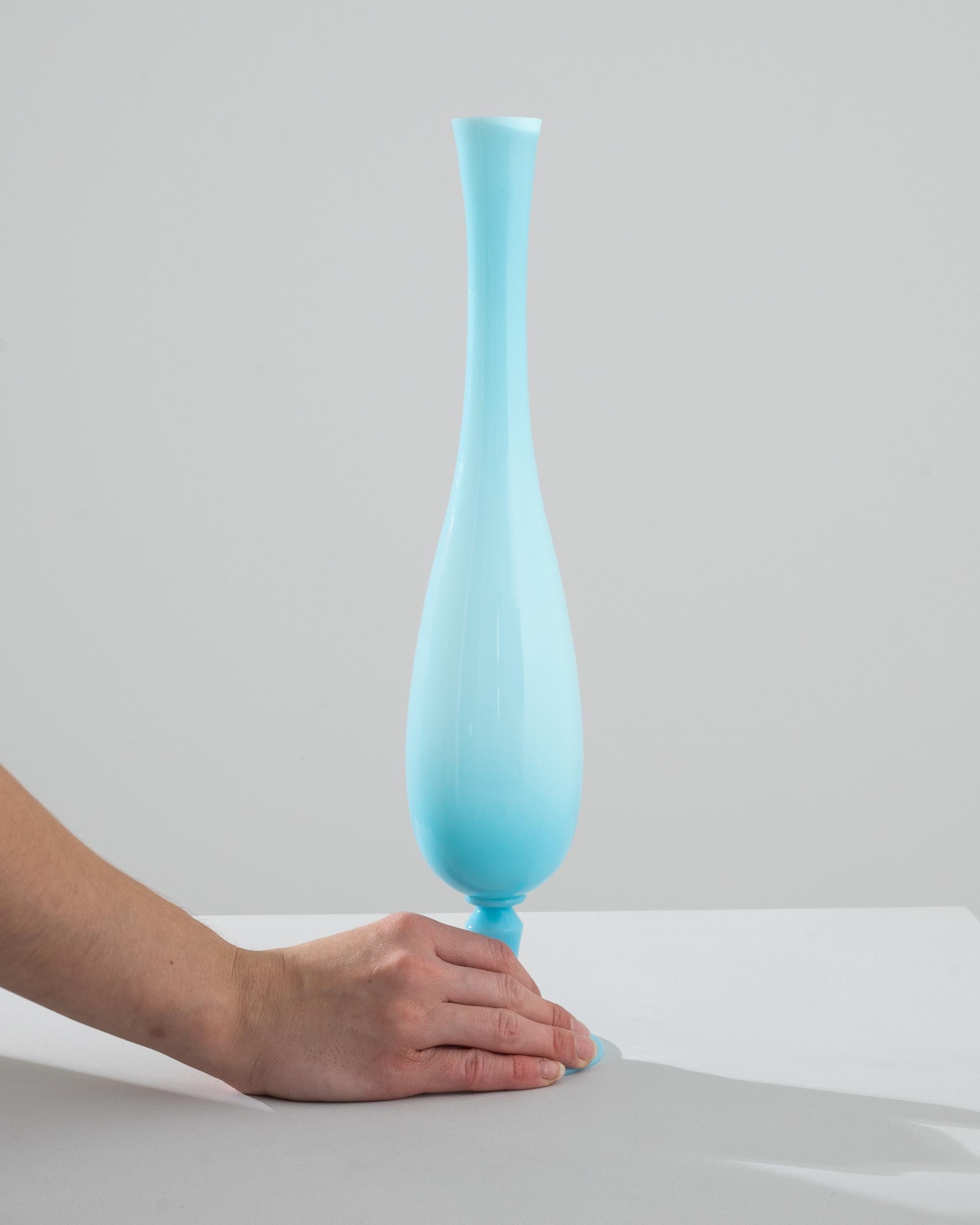 Elevate your home décor with the sublime elegance of this 1960s Italian Blue Glass Vase, a stunning piece that captures the essence of classic Italian craftsmanship. Bathed in a serene sky blue, this vase is the epitome of sophistication, with a