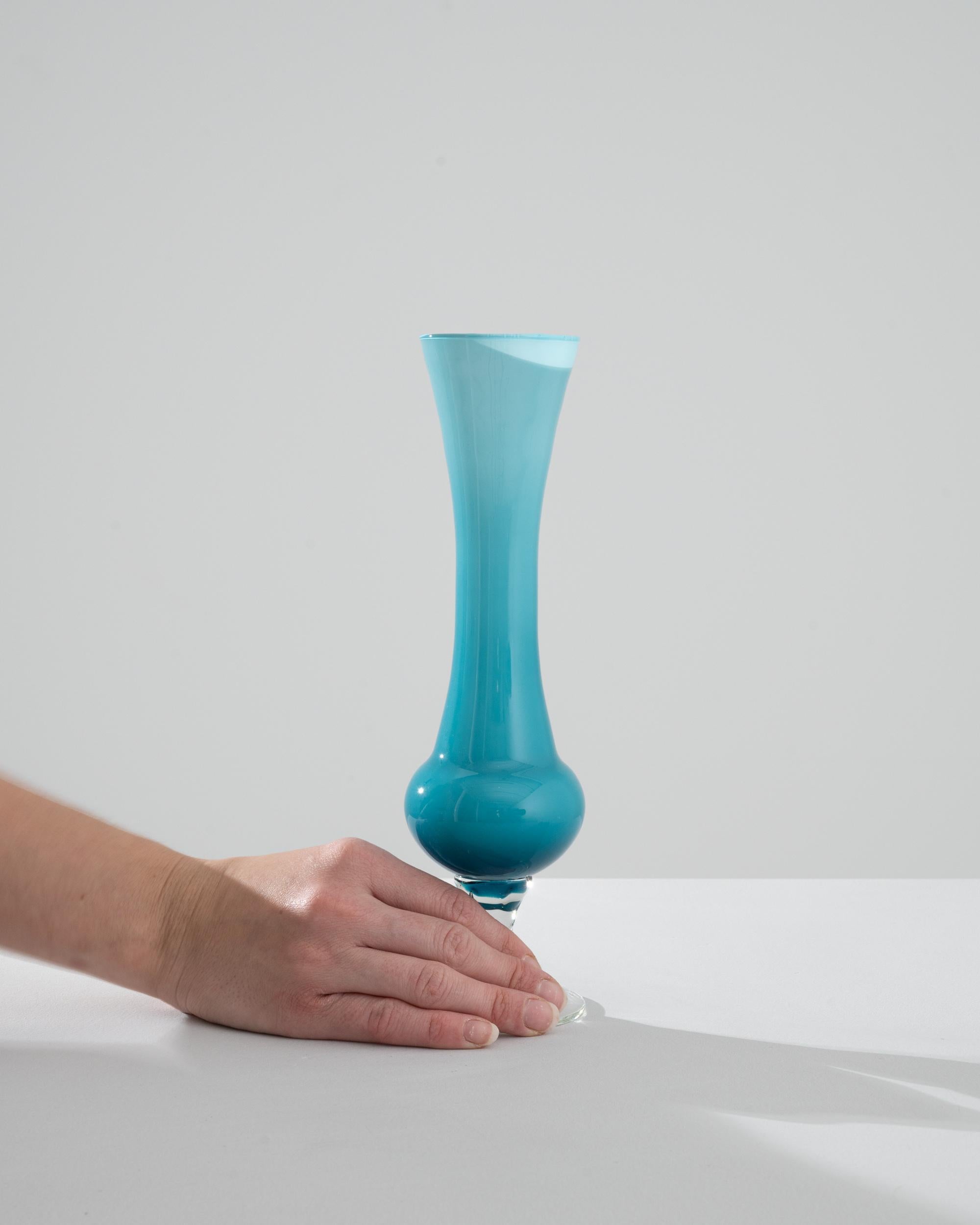 Discover the enchantment of Italian design with this captivating 1960s Italian Blue Glass Vase, a showcase of the era's passion for bold, flowing forms and vibrant colors. The vase's alluring sky blue color palette radiates tranquility, while its
