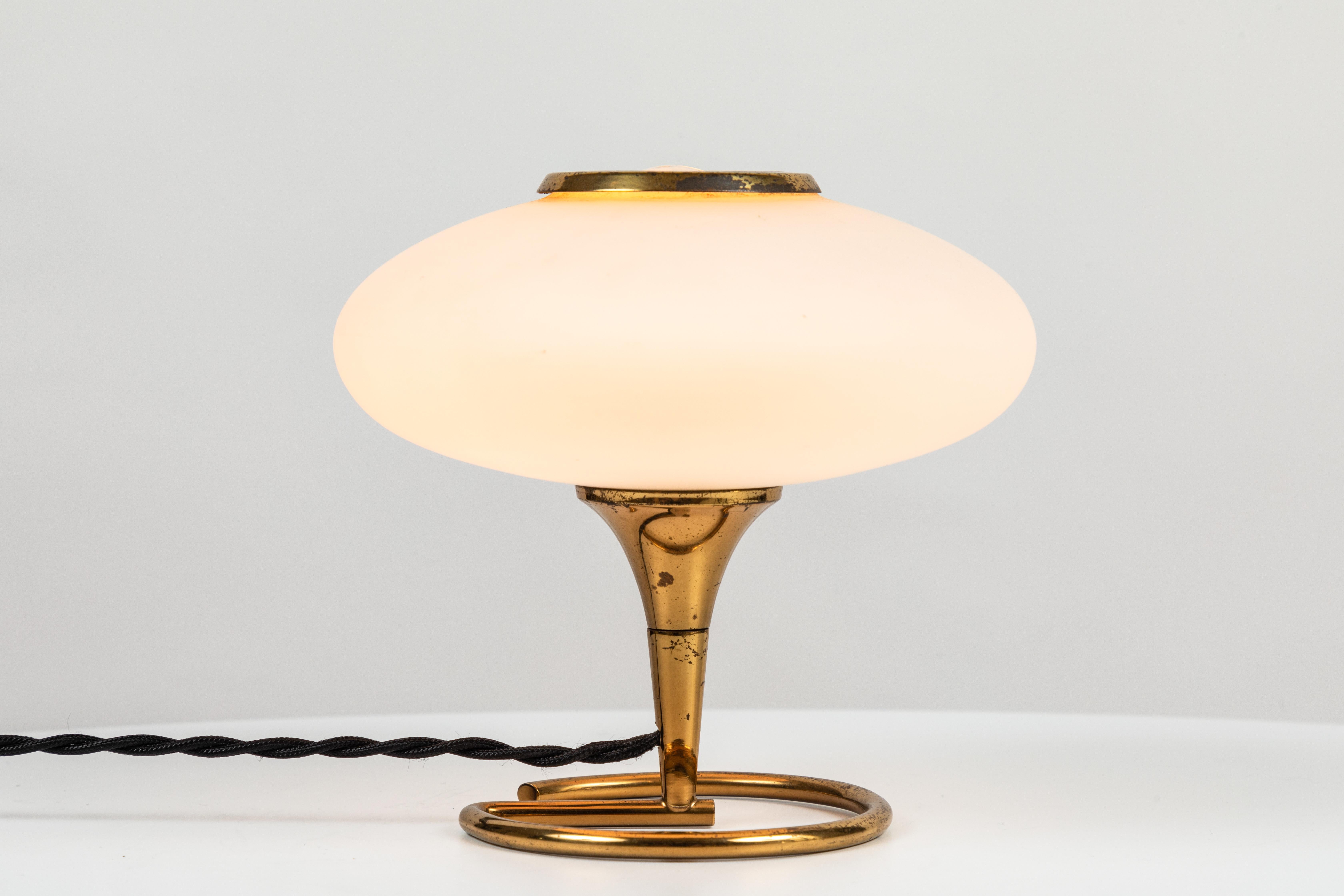 1960s Italian brass and glass table lamp attributed to Stilnovo. A delicate and whimsical table lamp executed in opaline glass and brass. A quintessentially midcentury Italian design reflecting the highest levels of materials, craftsmanship and