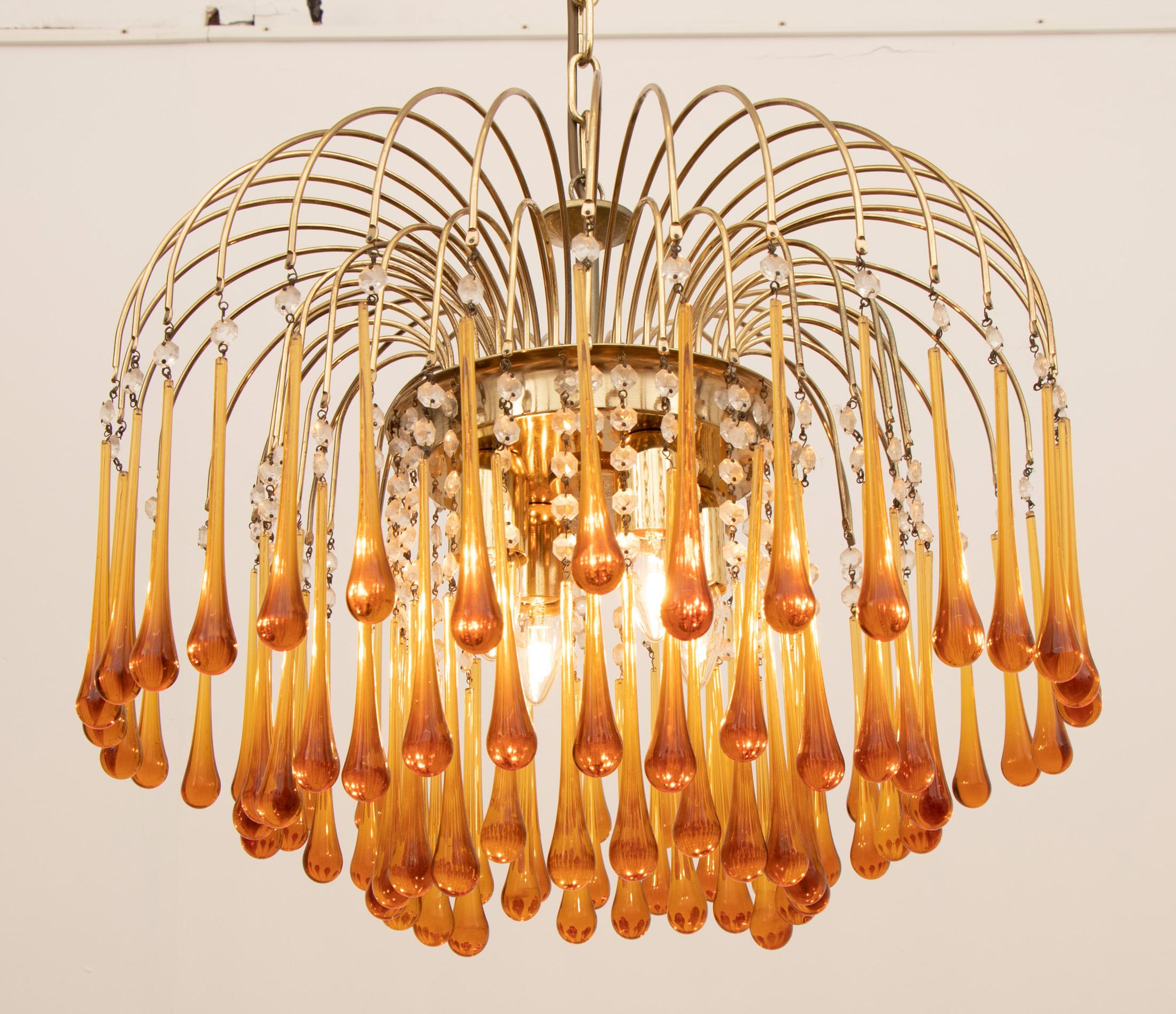 A beautiful and striking vintage 1960s Italian, Murano, amber glass, cascading, chandelier designed by Paolo Venini. There are three-tiers of amber glass teardrops suspended from brass stems with clear glass pearls diving the two. Four large E27