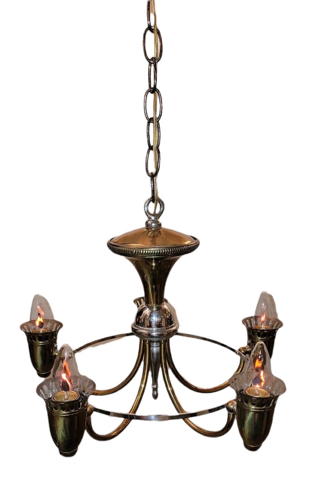 Italian brass five light chandelier with a retro look. the rounded look edges provide a sleek look while the lights add a subtle glare to the brass. Very nice and sleek look.

Measures: 13 high 16 diameter addition of chain is an extra 16 inches.
