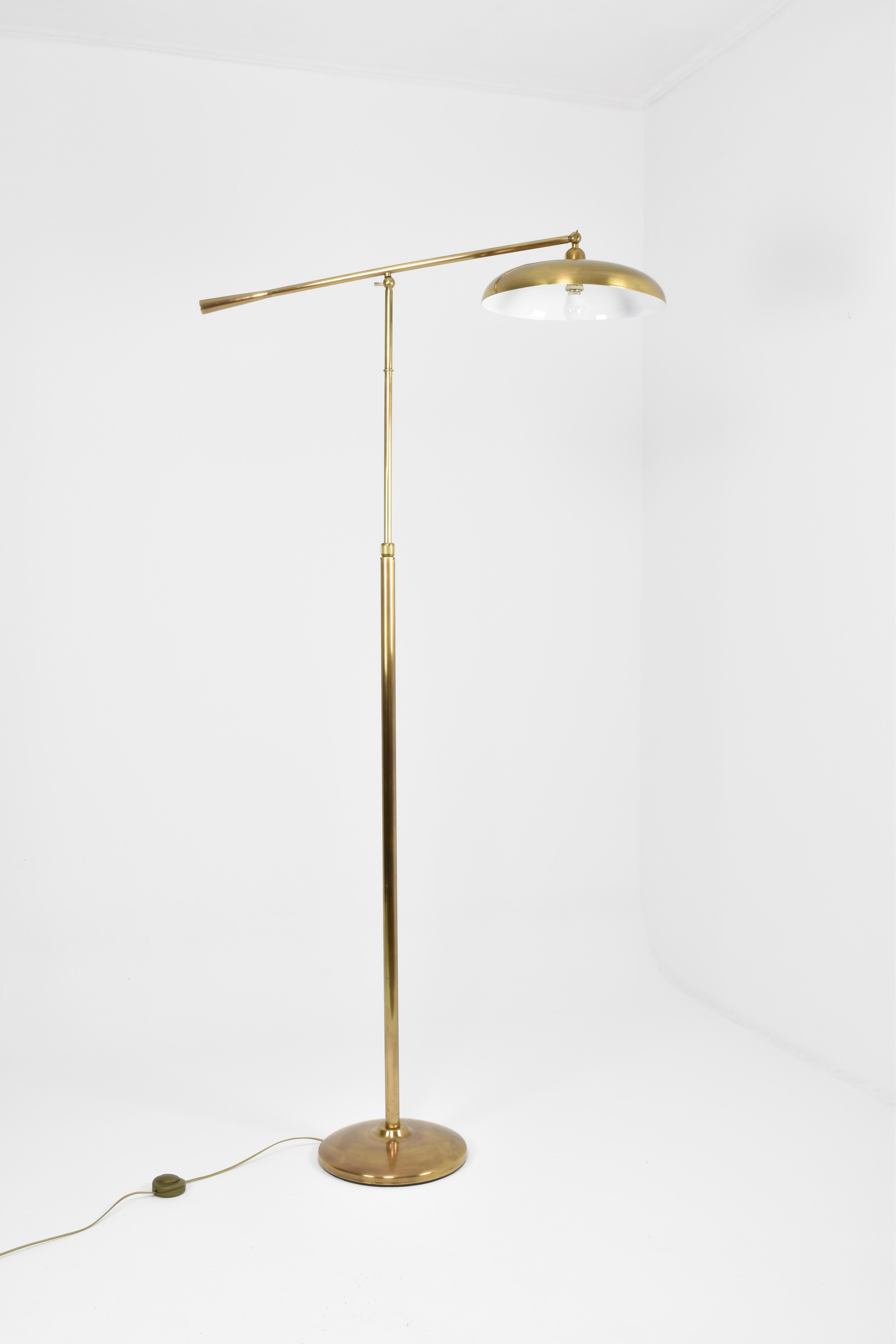 Vintage Italian brass floor lamp from the 1960s, featuring an adjustable arm and a circular shade. Crafted with exquisite attention to detail, this practical statement lighting piece is both timeless and elegant. 

Maximum height of 195 cm
Minimum