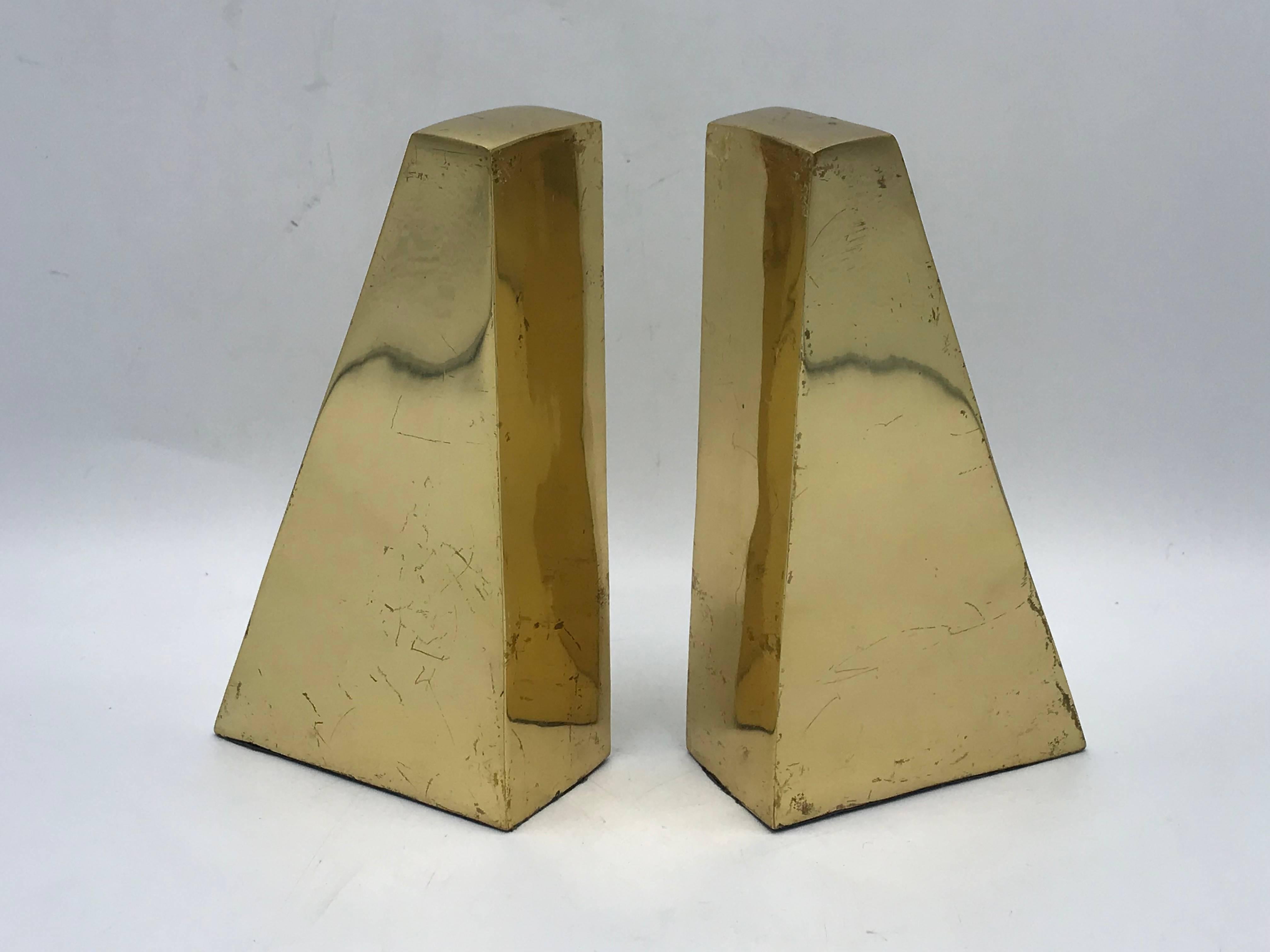 Listed is a stunning, pair of 1960s Italian brass bookends. The pieces are in a mirrored, minimal-modern triangular shapes. Extremely heavy, padded bottom.
