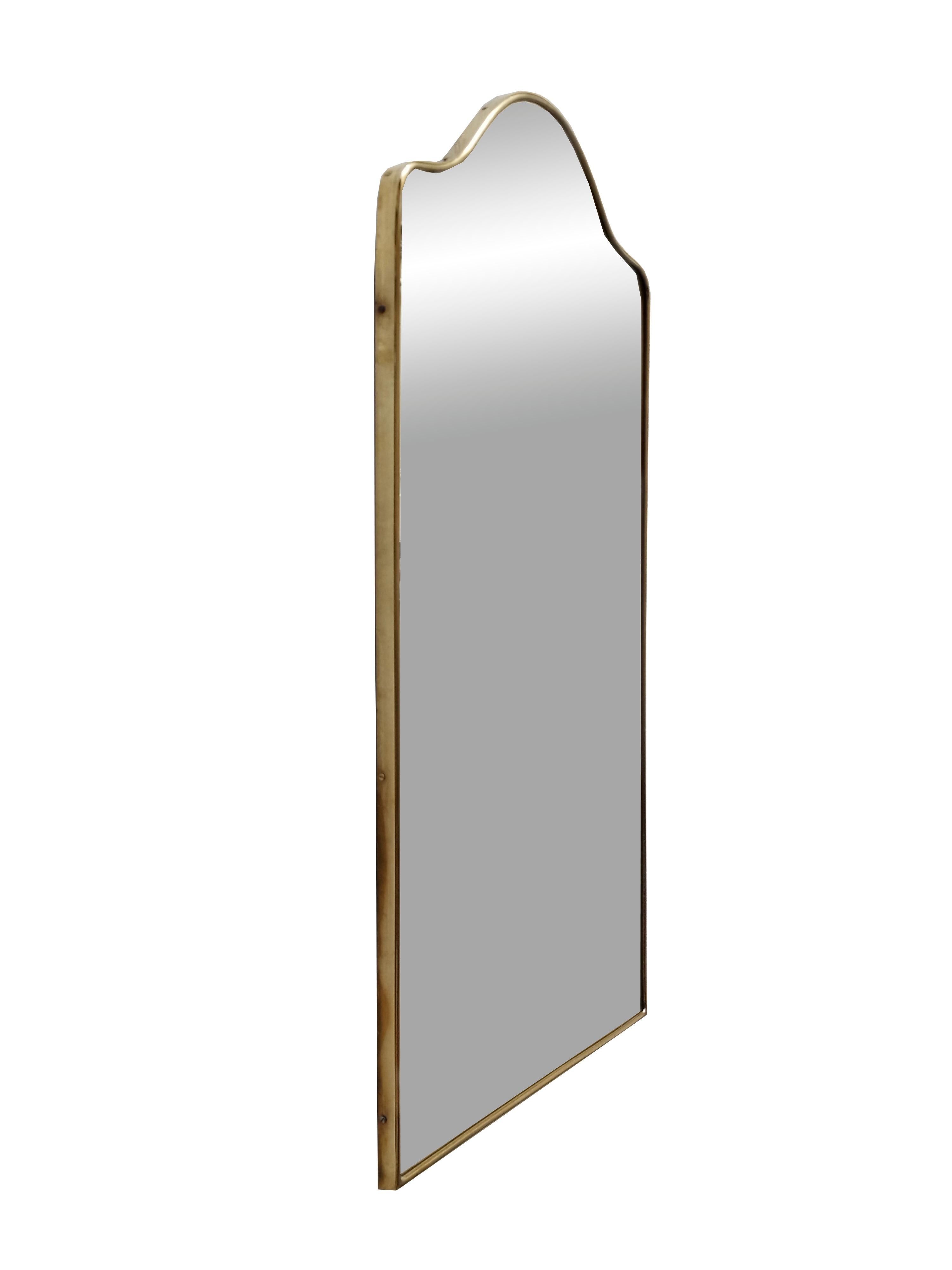 Wall mirror with brass frame, made in the 1960s in the style of Giò Ponti. The frame shows some signs of time.

