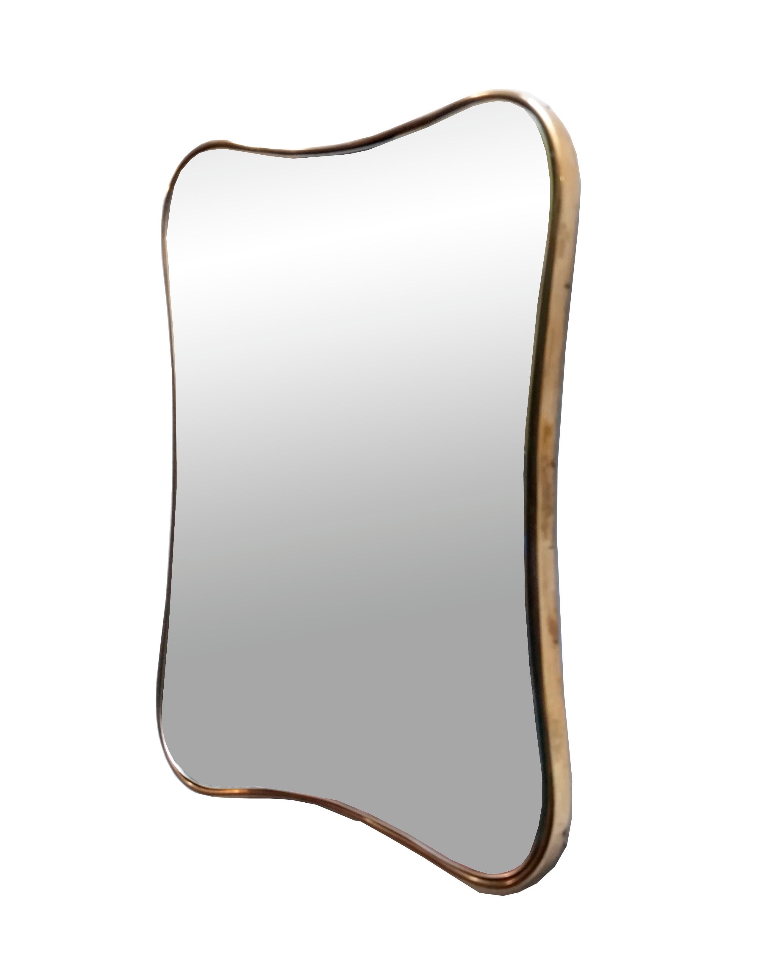 Shaped mirror with brass frame, 1960s. Showing some minor signs of time, the mirror is original to the period.
 