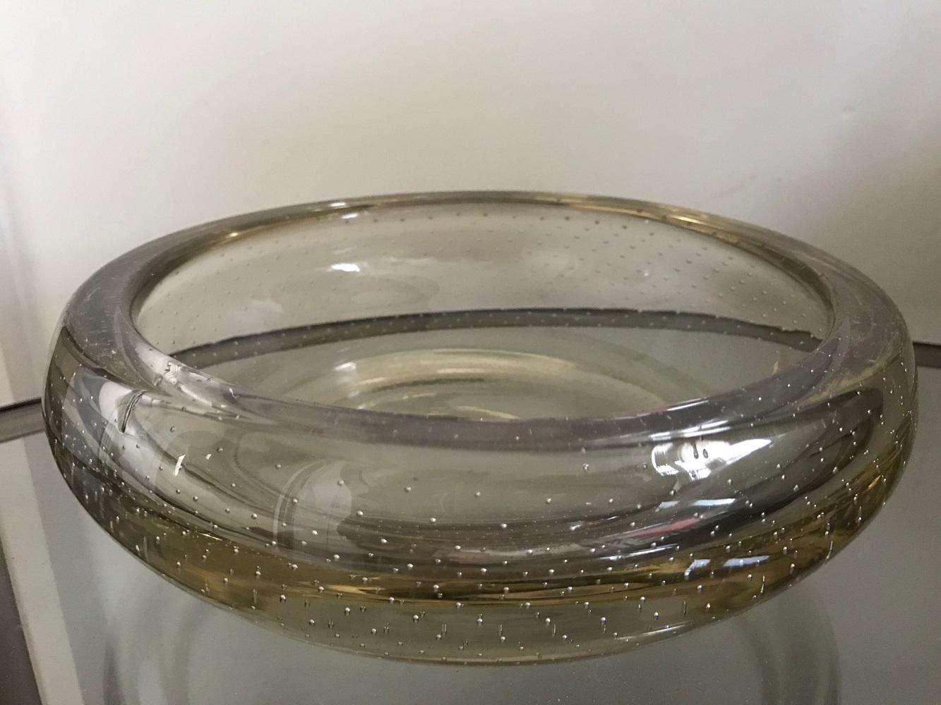 A large heavy controlled bubble glass vide poche or bowl. Clear glass with a slight gold tint. No makers mark, but think it is Italian. Good pontil and in very good condition. Beautiful decorative object, which would complement any interior.