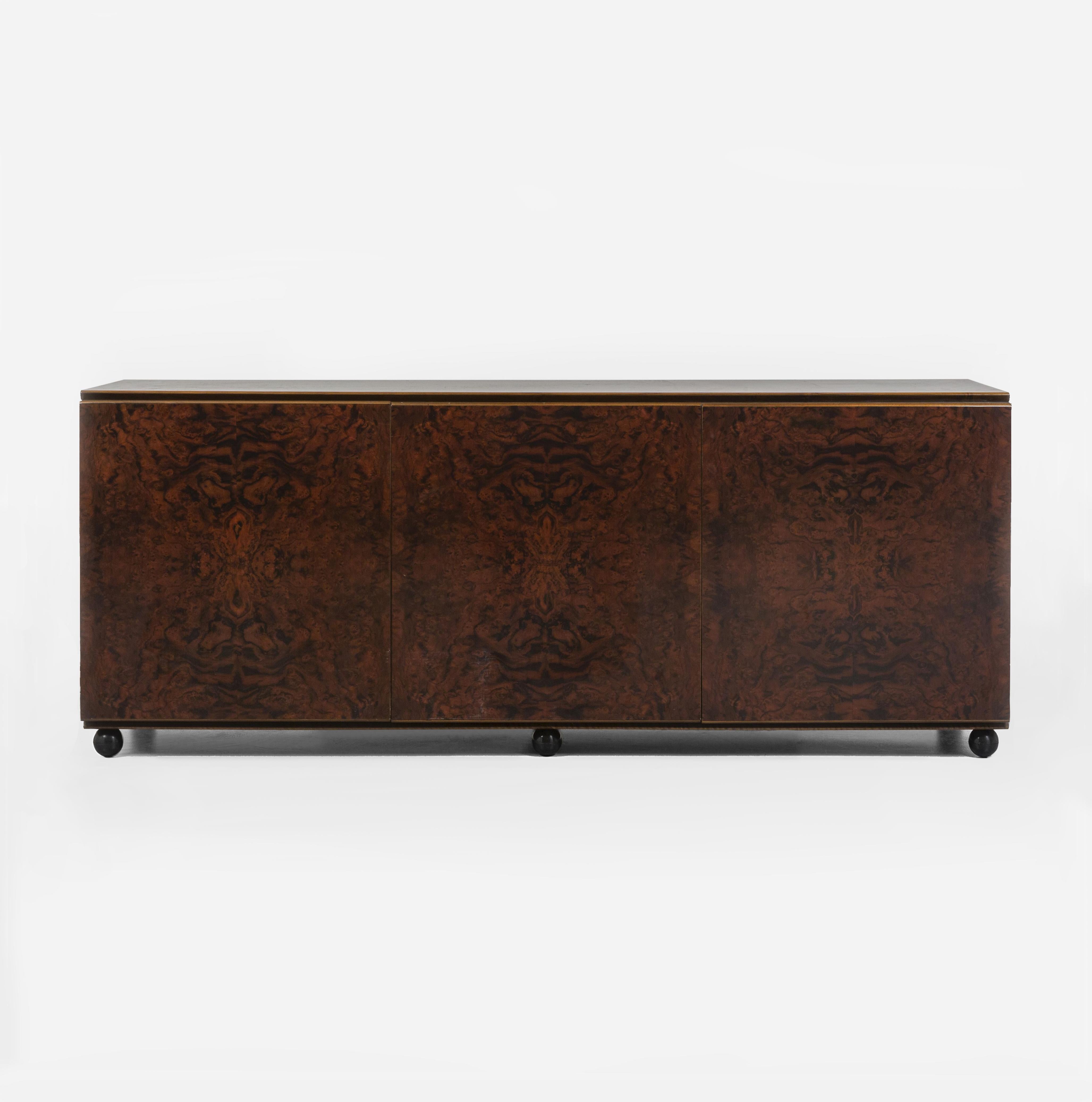 This is a stunning Italian sideboard made in the 1960s. It is made of dark brown burr walnut veneer on the outside (both front and back) and another lighter walnut veneer on the inside. The wood is varnished which makes it really high end. 
It has