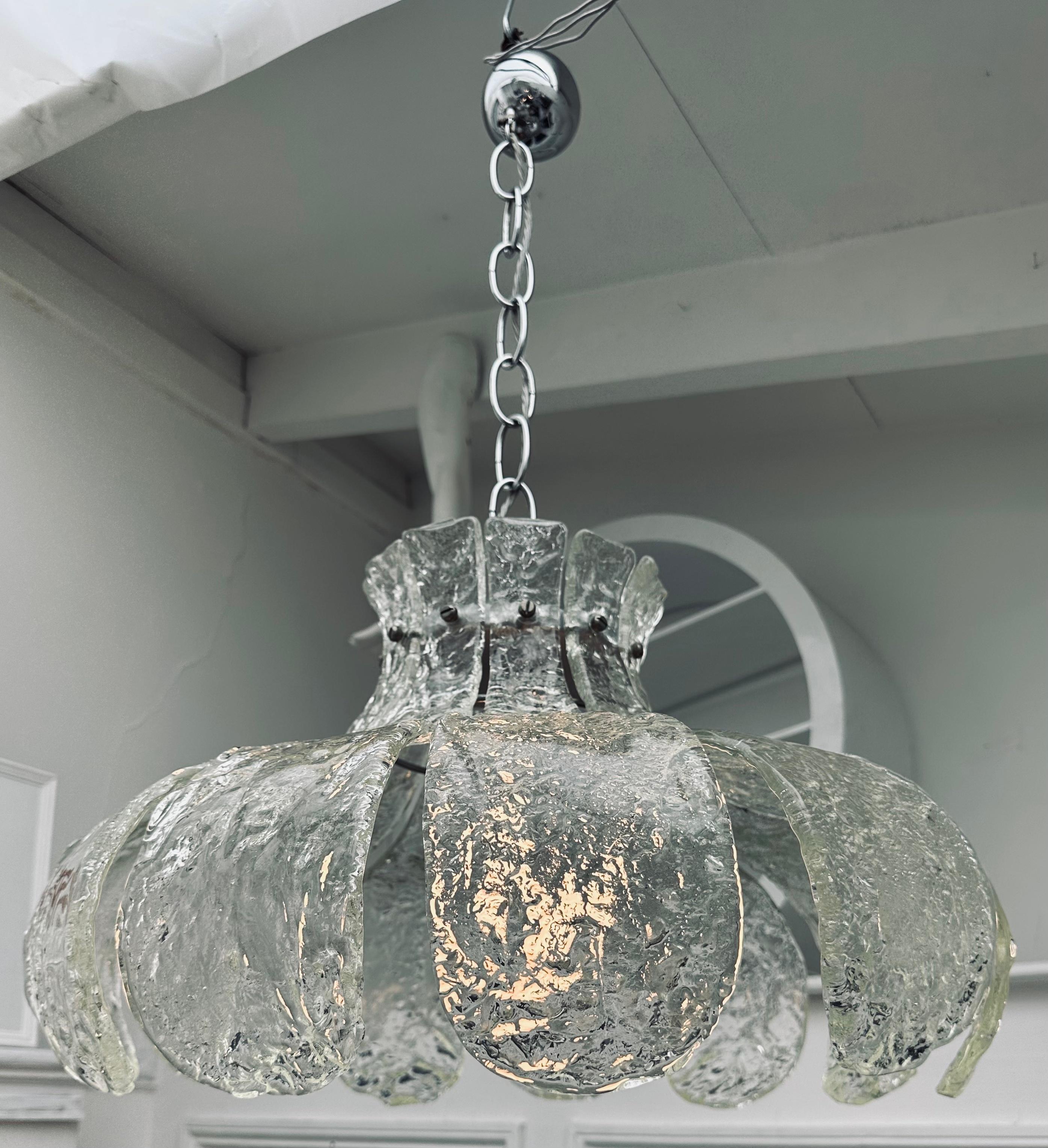 Suspension italienne en verre de Murano datant du milieu des années 1960, composée de 11 pétales individuels en verre transparent épais et texturé, fixés à l'aide d'une petite vis chromée à tête plate sur un cadre en métal chromé pour former une