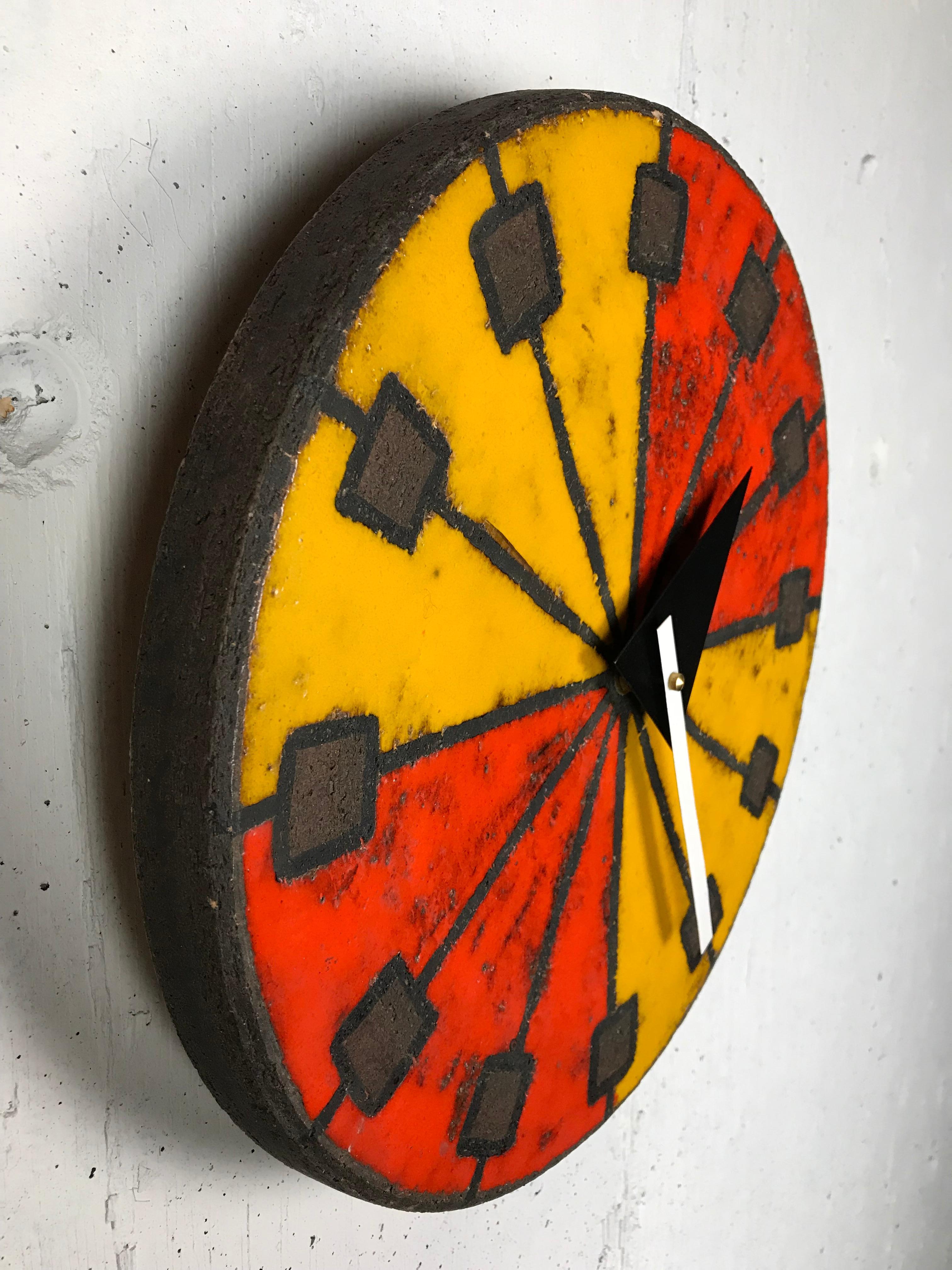 Eye-catching modernist Italian ceramic wall clock by Bitossi (Italian potter) manufactured by Howard Miller using hands designed by George Nelson (American designer). This desirable glaze has brilliant red and orange colors and a sgraffito technique