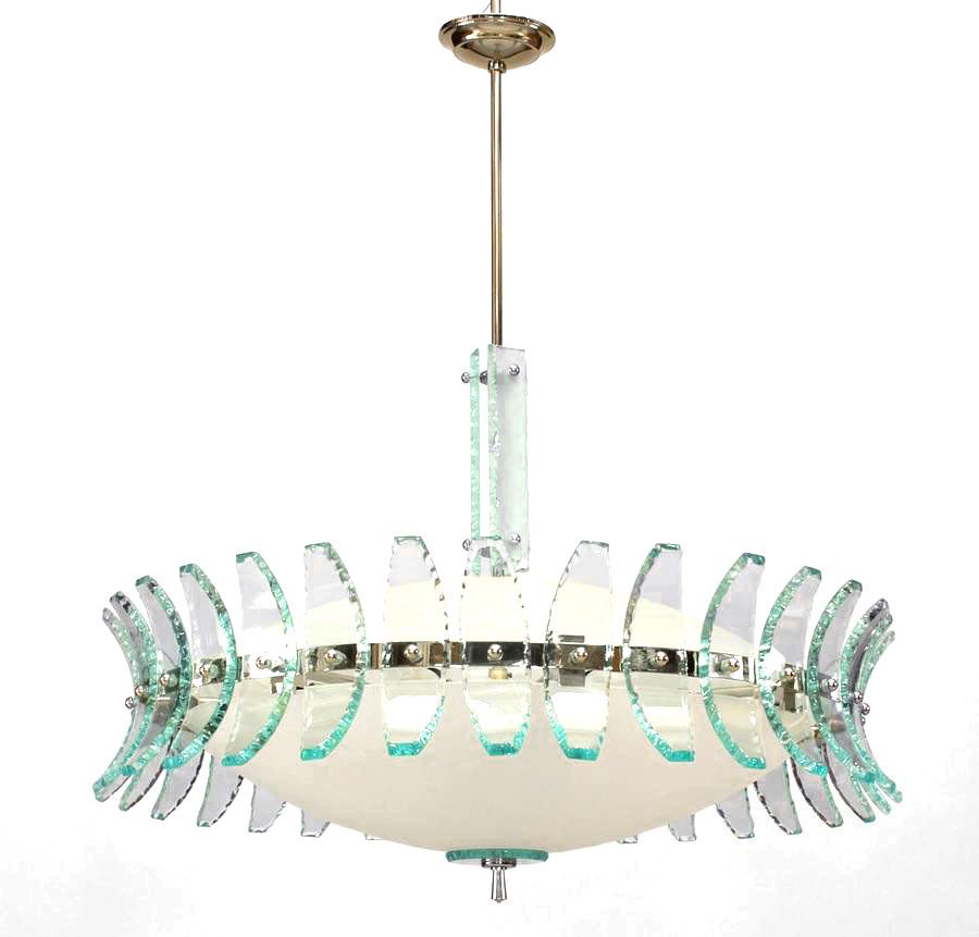 1960s Italian chandelier attributed to Fontana Arte. The chandelier's round perimeter covered with applied aqua slag glass panels which surround a frosted glass shade supported by a chrome finial and stem.


Under the art direction of the great Gio