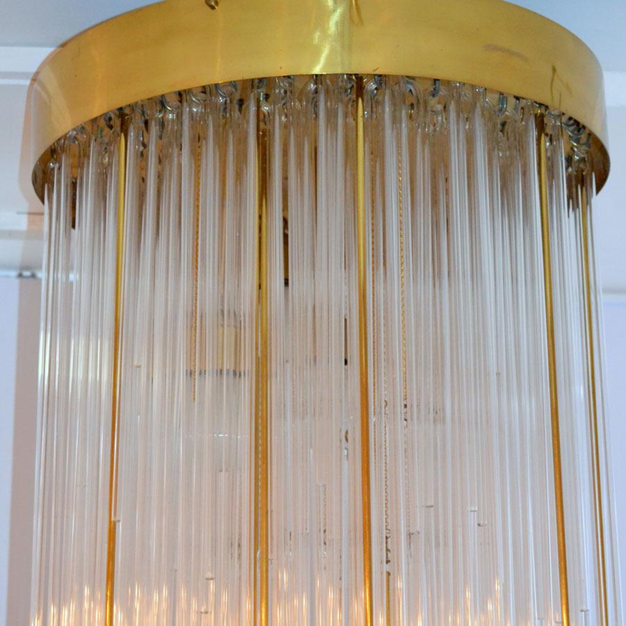 Spectacular Mid-Century Modern tier glass and brass flushmount chandelier is like a waterfall. The stylish brass border holds a frame of which 250 thin strands of cascading glass and brass hang in differing lengths. They are individually hooked on