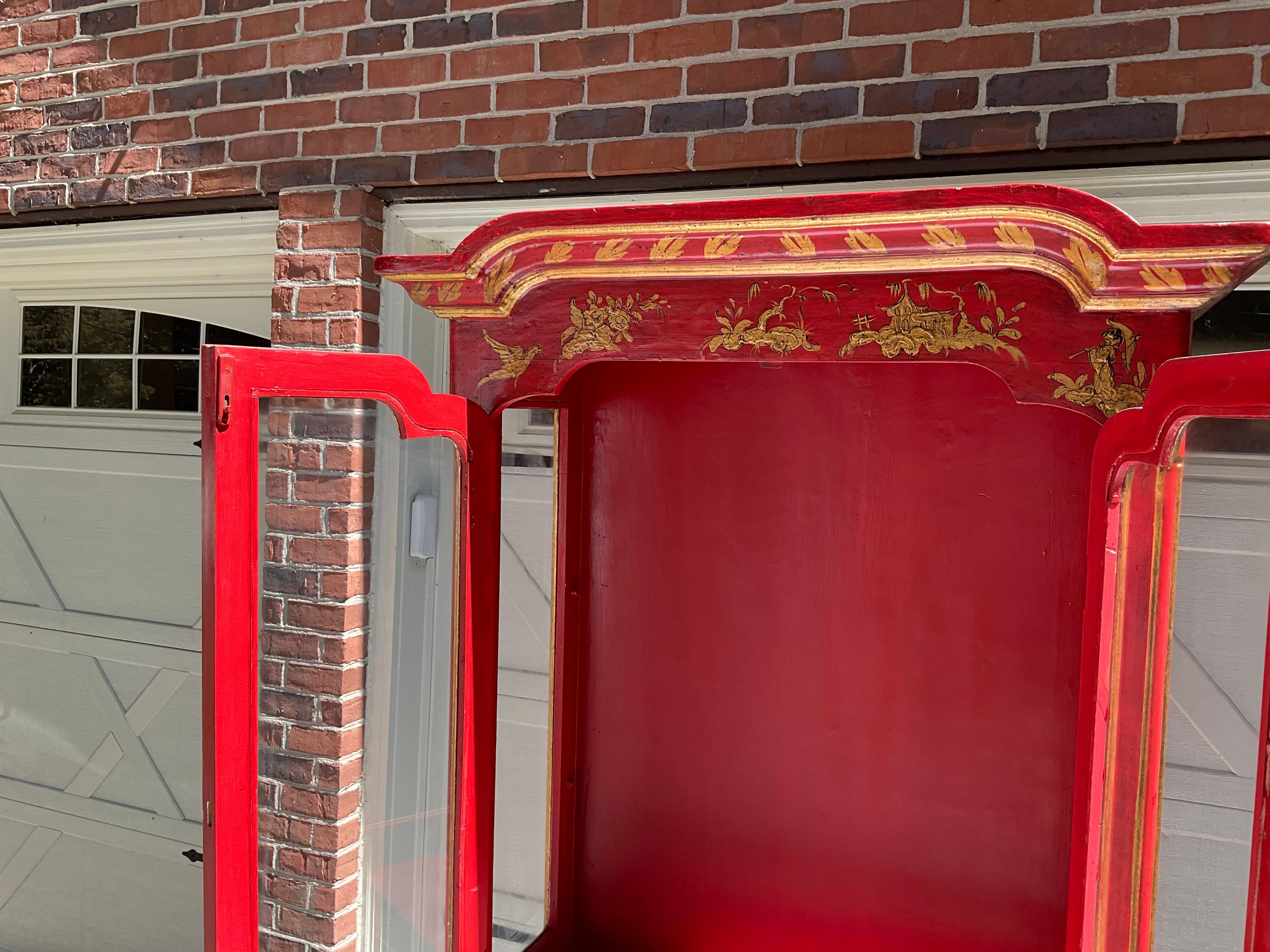 What a statement piece! Gorgeous, Italian 4 door cabinet with a chinoiserie motif. In very good estate condition, with only slight wear. Upper doors have glass with the base cabinet solid panels. The upper cabinet includes 2 removable glass shelves.