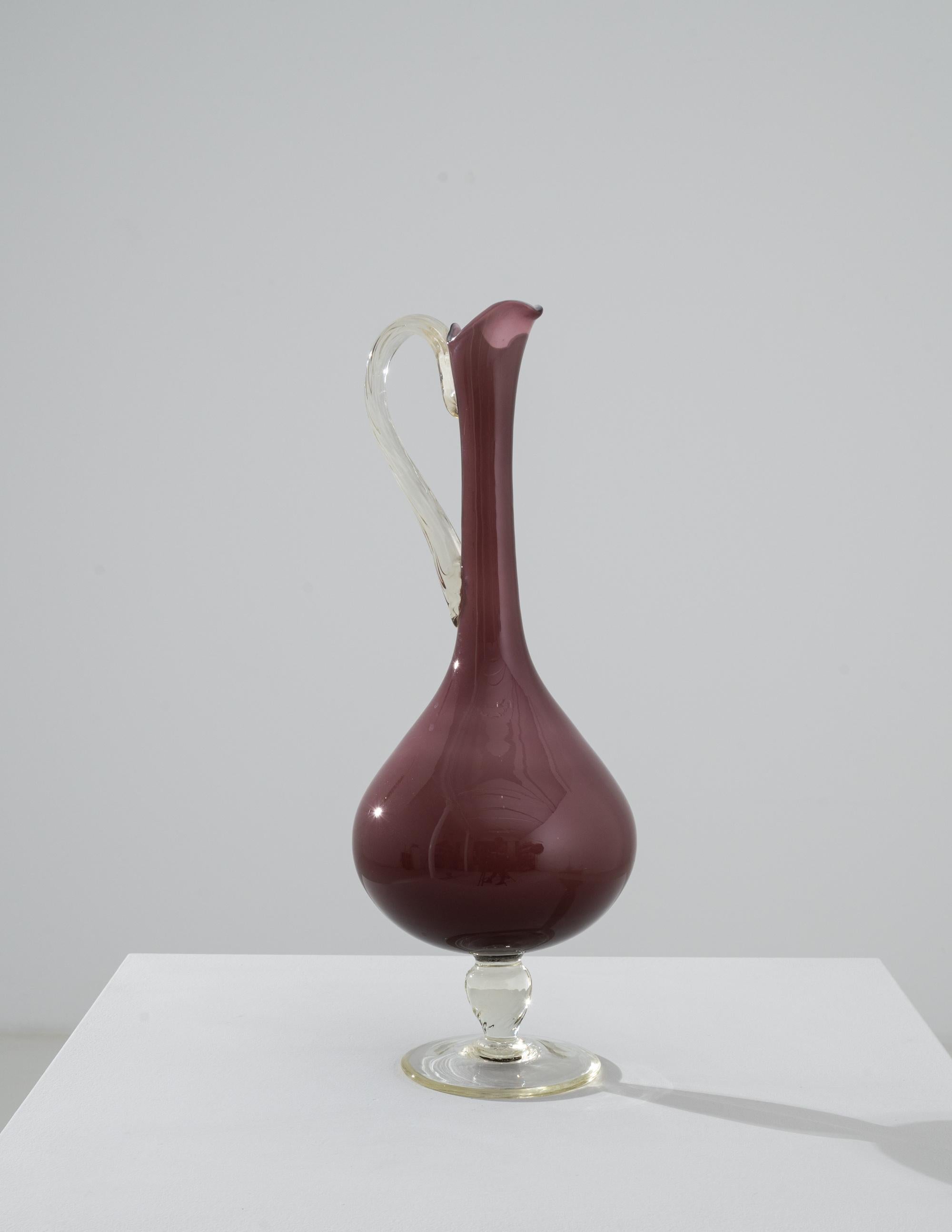 Romantico e suggestivo, questo vaso in vetro offre un accento vintage unico. Realizzata in Italia negli anni '60, la forma è elegante e penetrante: un manico sottile si fonde con grazia con il vaso di vetro colorato. Splendidamente realizzato, il
