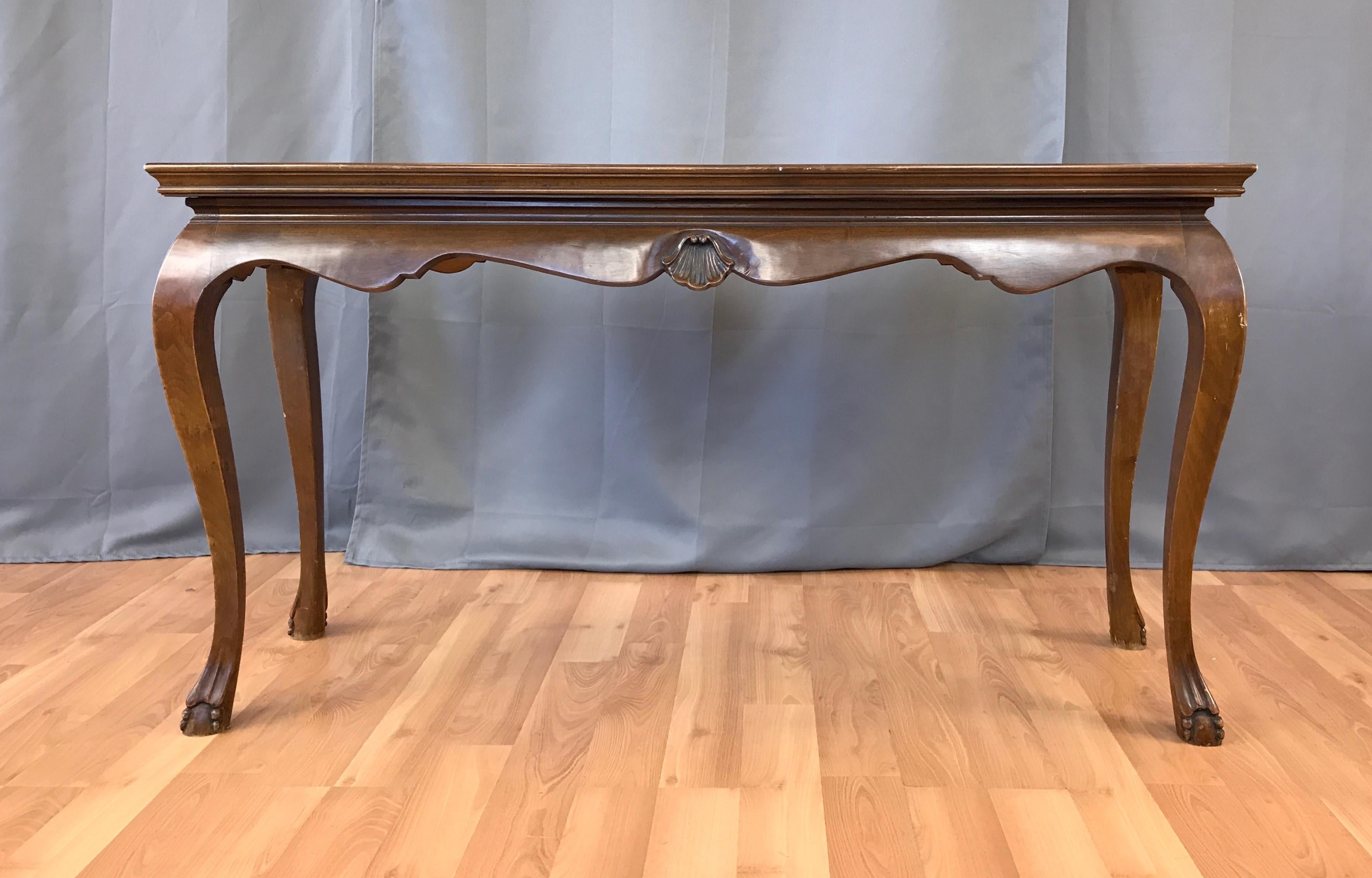 This circa 1960s narrow Italian console or sofa table features a rich grained walnut burl of several pieces fitted together to form a continuous surface. The cabriole legs end in a stylized ball and claw feet. The legs tradition nicely into the