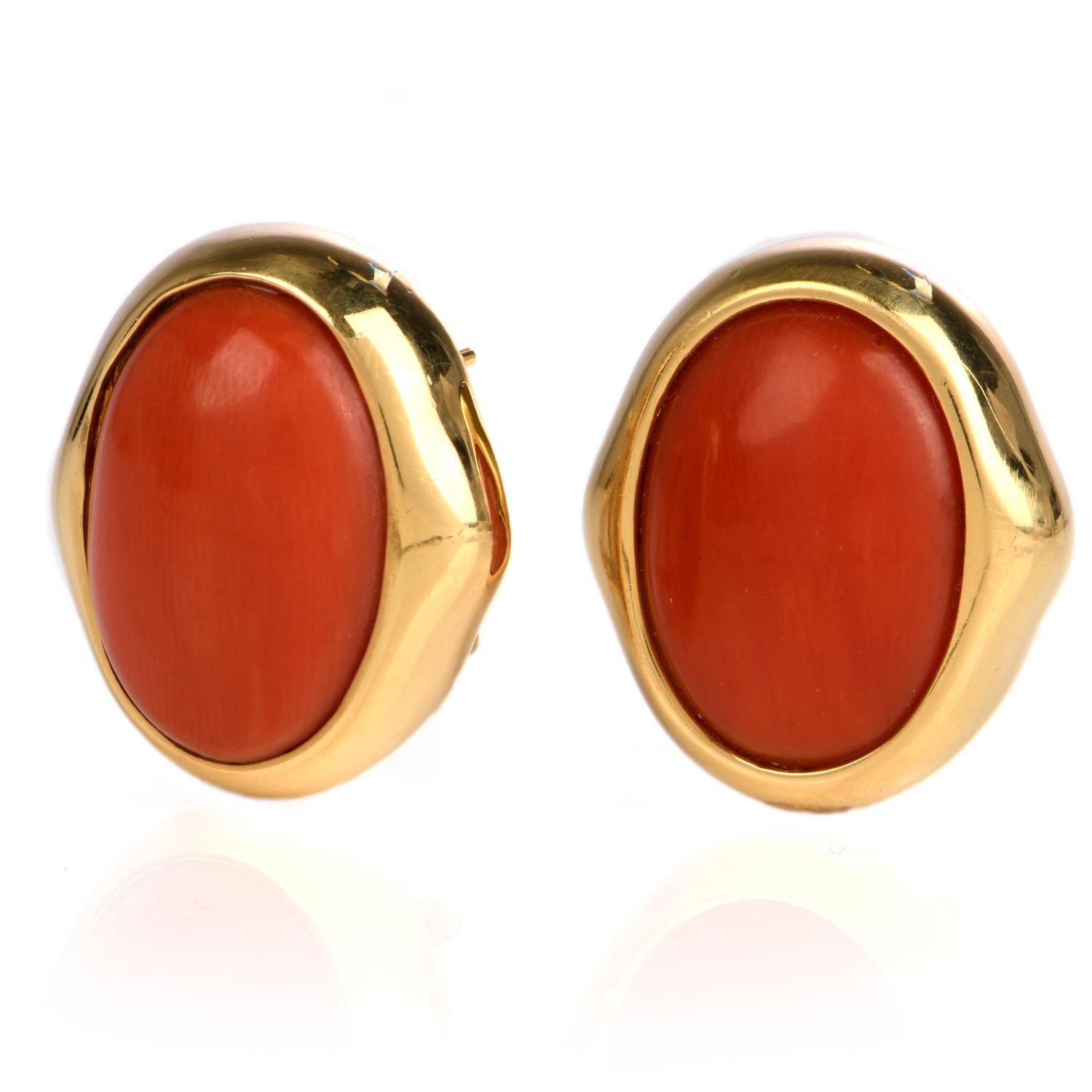 These retro chic Natural coral earrings are crafted in solid 18-karat yellow gold, weighing 16.5 grams and measuring 22mm long x 19mm wide. Showcasing a pair of bezel-set natural salmon coral oval cabochons. Secure with post and lever back, signed,