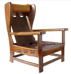 Coppia di poltrone in pelle e legno di design italiano degli anni '60