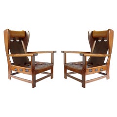 Coppia di poltrone in pelle e legno di design italiano degli anni '60