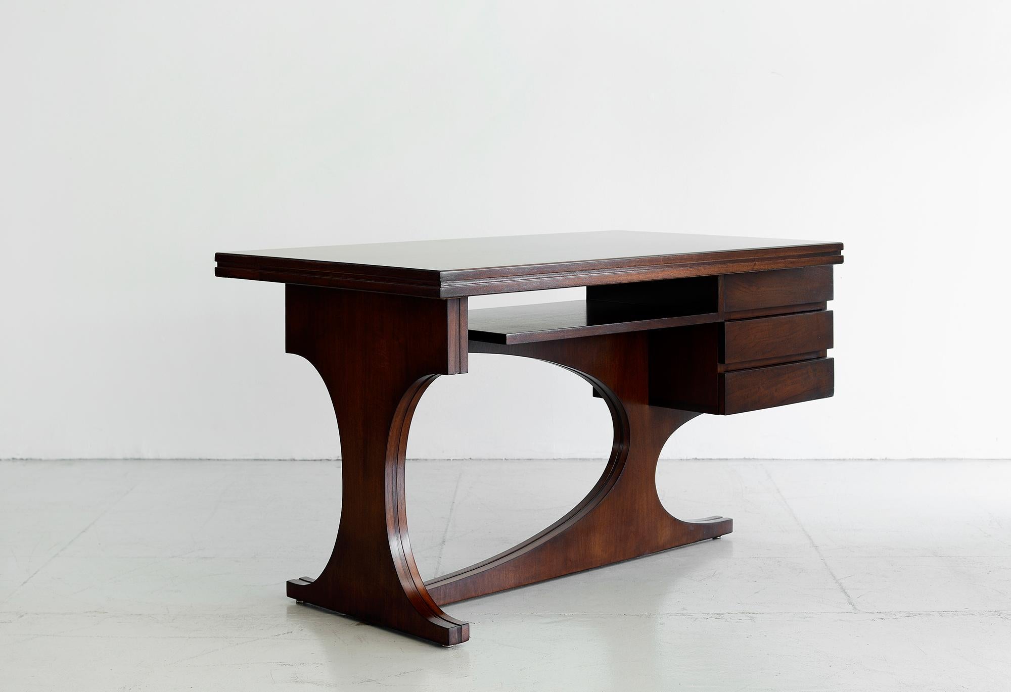 Unique Italian desk designed by Adriano Colombo, Pietro Galli, Vittorio Tavecchia
Single pedestal mahogany wood desk with 3 drawers on floating sculptural base,
circa 1960s and produced by Fratelli Asnaghi.

 