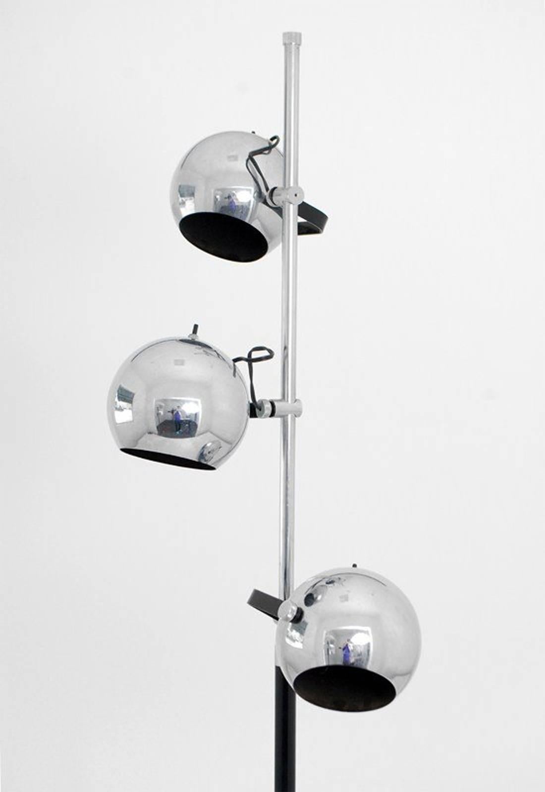 A 1960s floor lamp, style of Arredoluce consisting of three adjustable heads, each with its own on/off switch, mounted along a tubular center column (the top in chrome and the bottom in black-enameled steel). The underside of the Carrara marble base