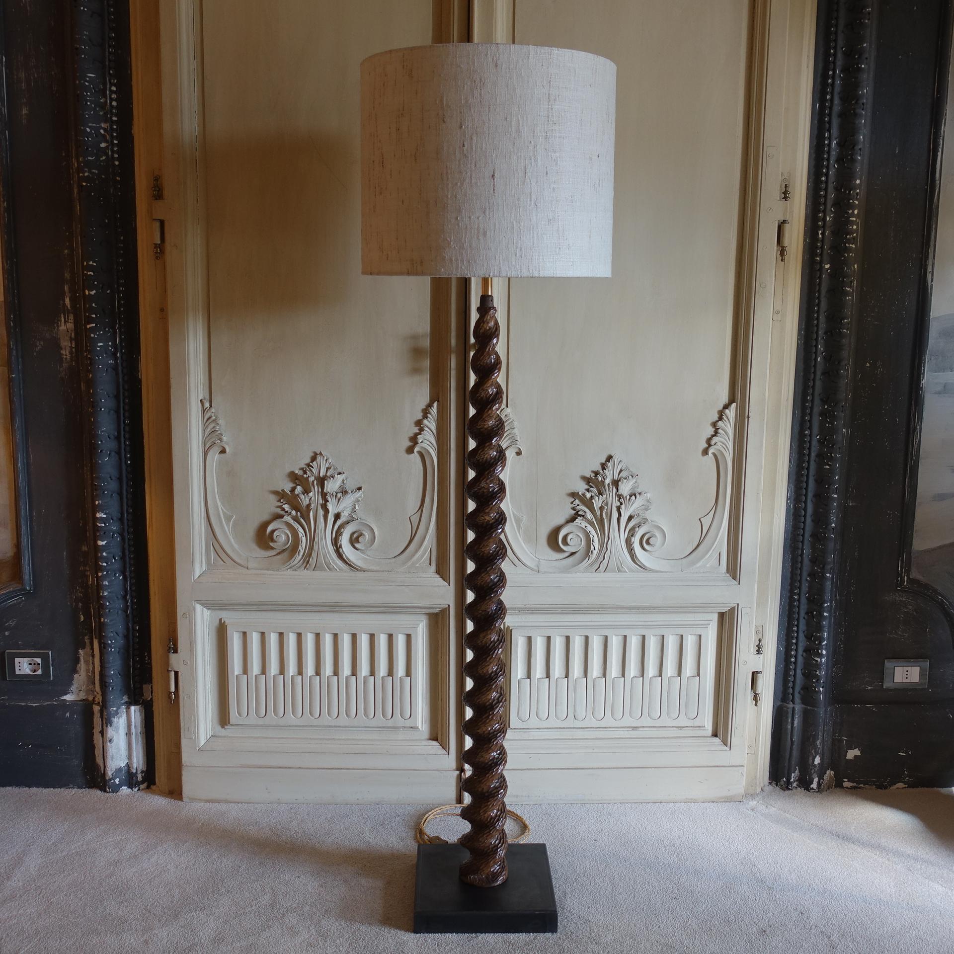 One of a kind floor lamp realized with 1960s spiral carved wood element and brutalist steel base, vintage patina, base measures cm 30x30xh.142, raw silk shantung lampshade cm Dia.50xh.40, total height cm 177.