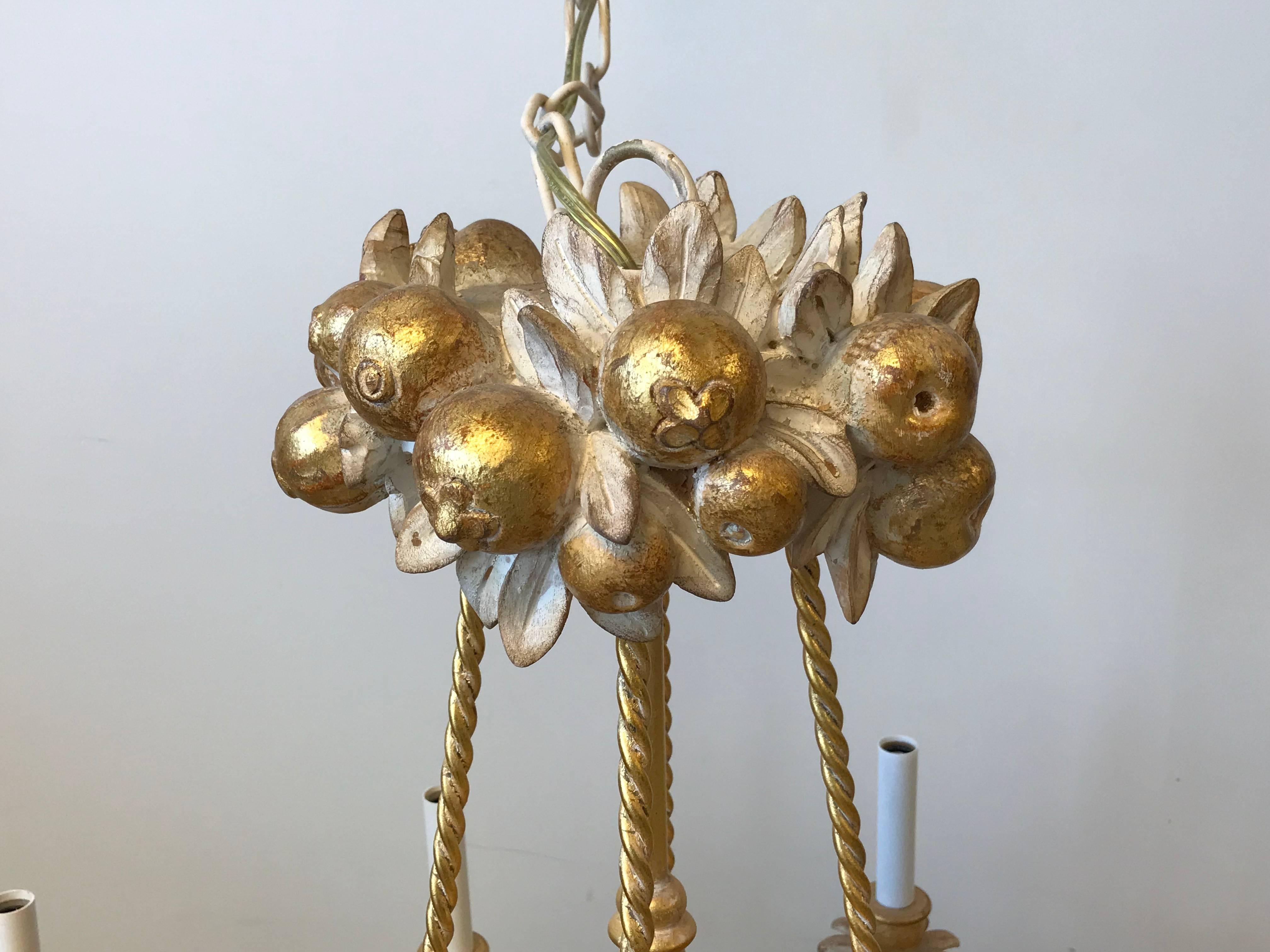 Listed is a fabulous, 1960s Italian Florentine fruit basket chandelier. This stunning and unique eight-arm light-fixture has a gorgeous two-tiered sculptural fruit basket and gilt-metal rope detailing. 32 in of cord/chain. Includes matching ceiling