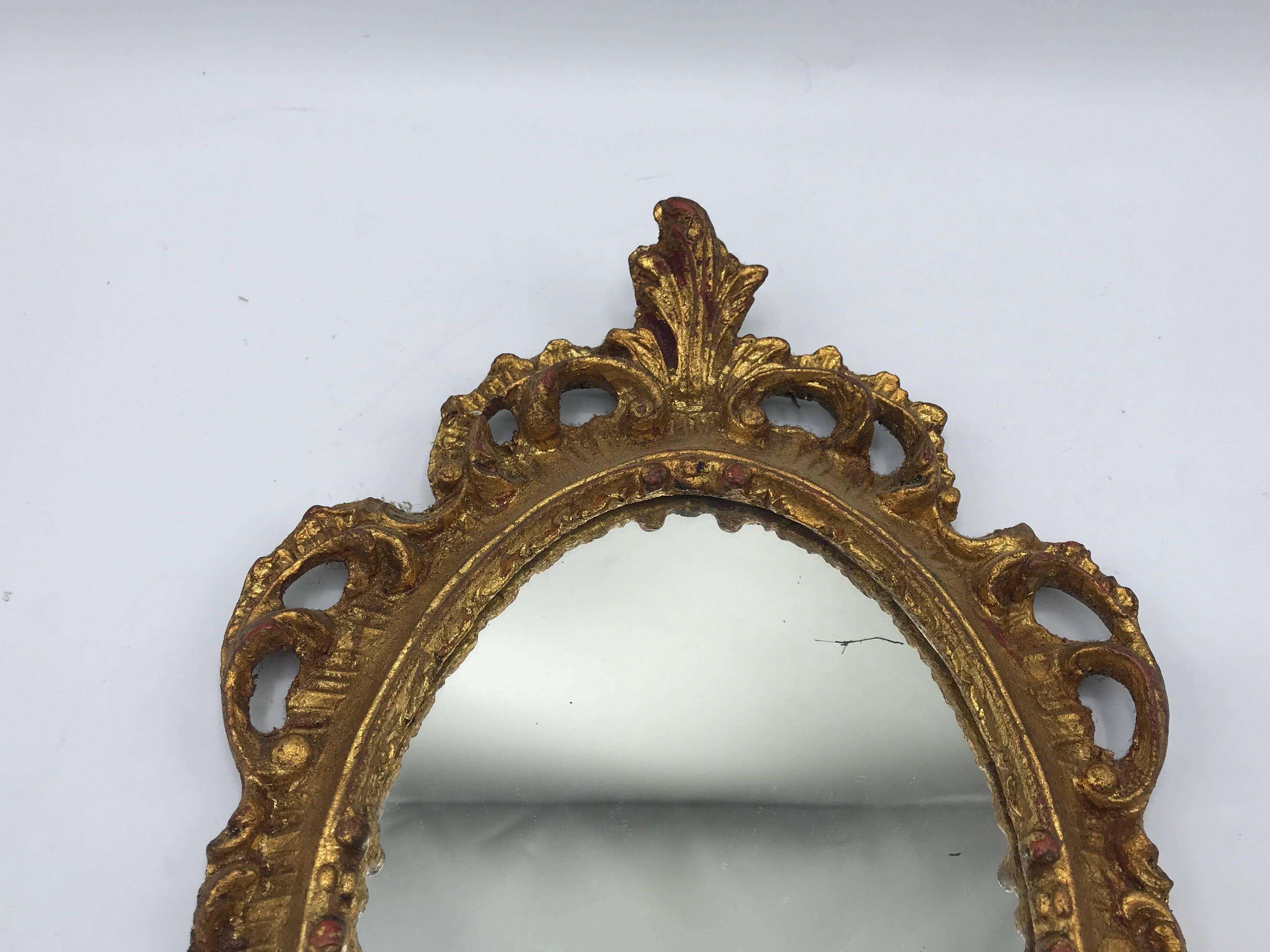 Offered is a fabulous, small/medium 1960s Italian Florentine oval gilded mirror. Beautiful, ornate carved details.