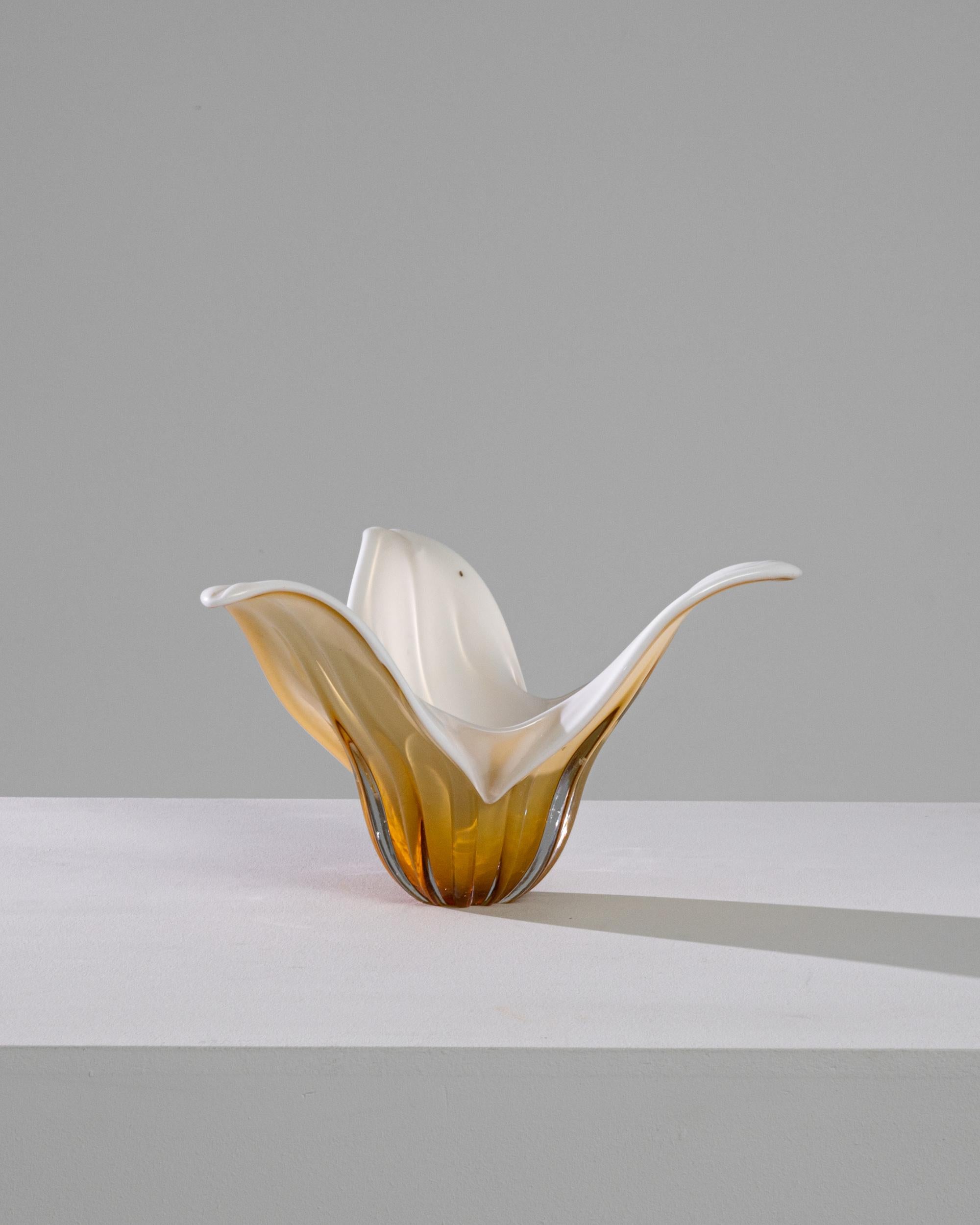 The liquid lines of this glass vase create an exquisite centerpiece. Made in Italy in the 1960s, expressive craftsmanship gives this piece a dynamic floral shape; a blossom captured in the instant of unfurling. Amber and golden tones at the base